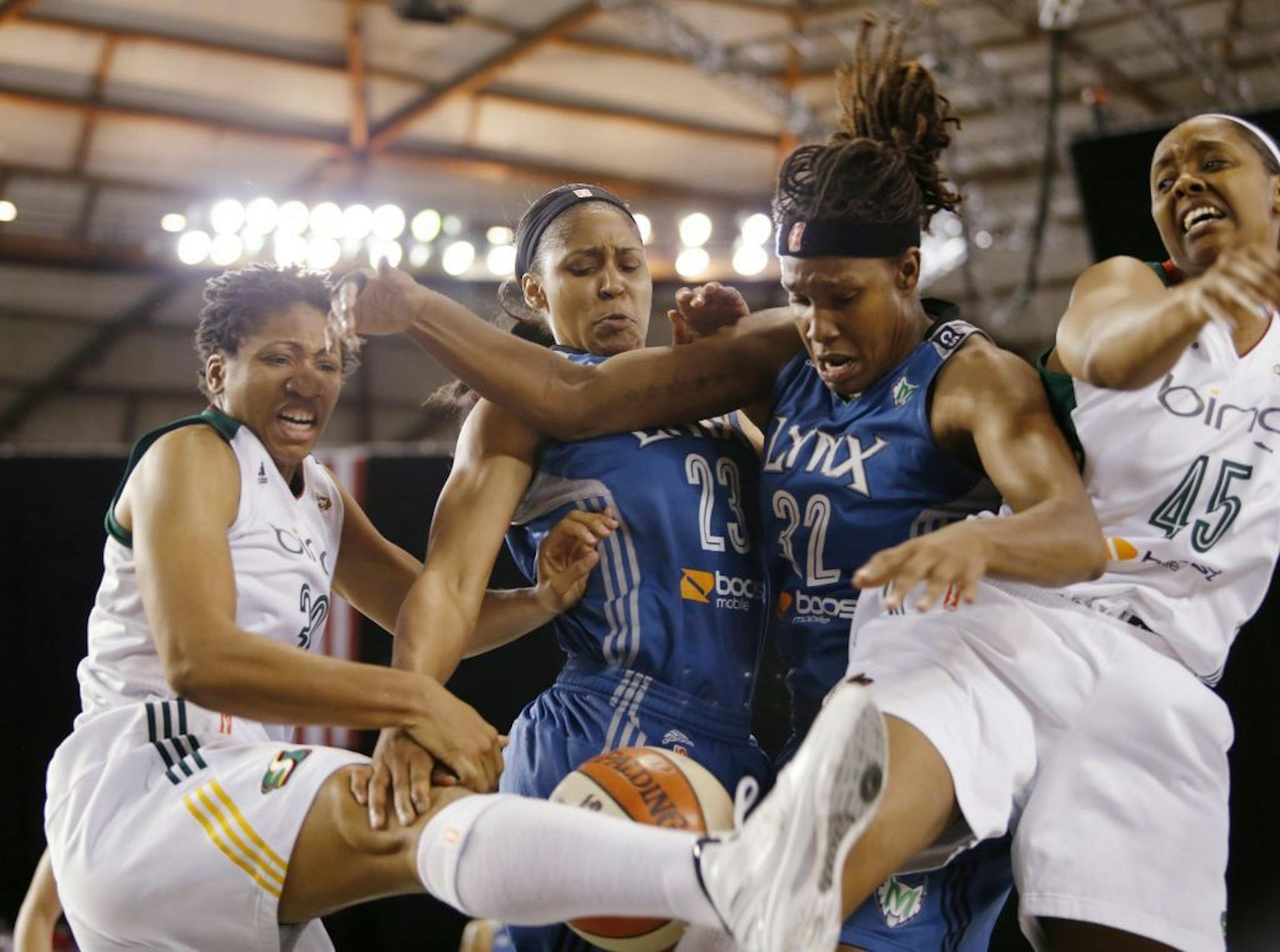 Seattle's Tanisha Wright, left, battled with the Lynx's Maya Moore (23) and Rebekkah Brunson (32) with Storm's Noelle Quinn, right for a rebound during the first half Sunday.
