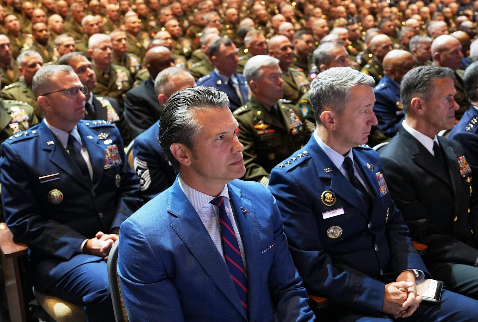 Defense Secretary Pete Hegseth, center, with U.S. military senior leadership as they listen to President Donald Trump at Marine Corps Base Quantico in Quantico, Va., on Tuesday.