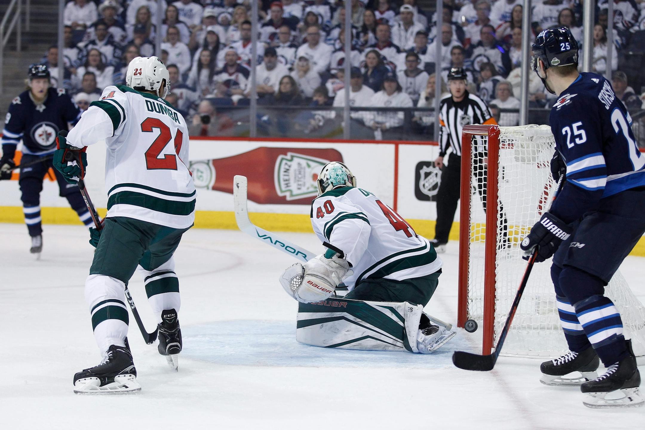 Winnipeg Jets' Paul Stastny (25) watces as a shot by Mark Scheifele, not seen, gets past Minnesota Wild goaltender Devan Dubnyk (40) as Matt Dumba (24) defends during the second period of Game 1 in an NHL hockey first-round playoff series Wednesday, April 11, 2018, in Winnipeg, Manitoba.