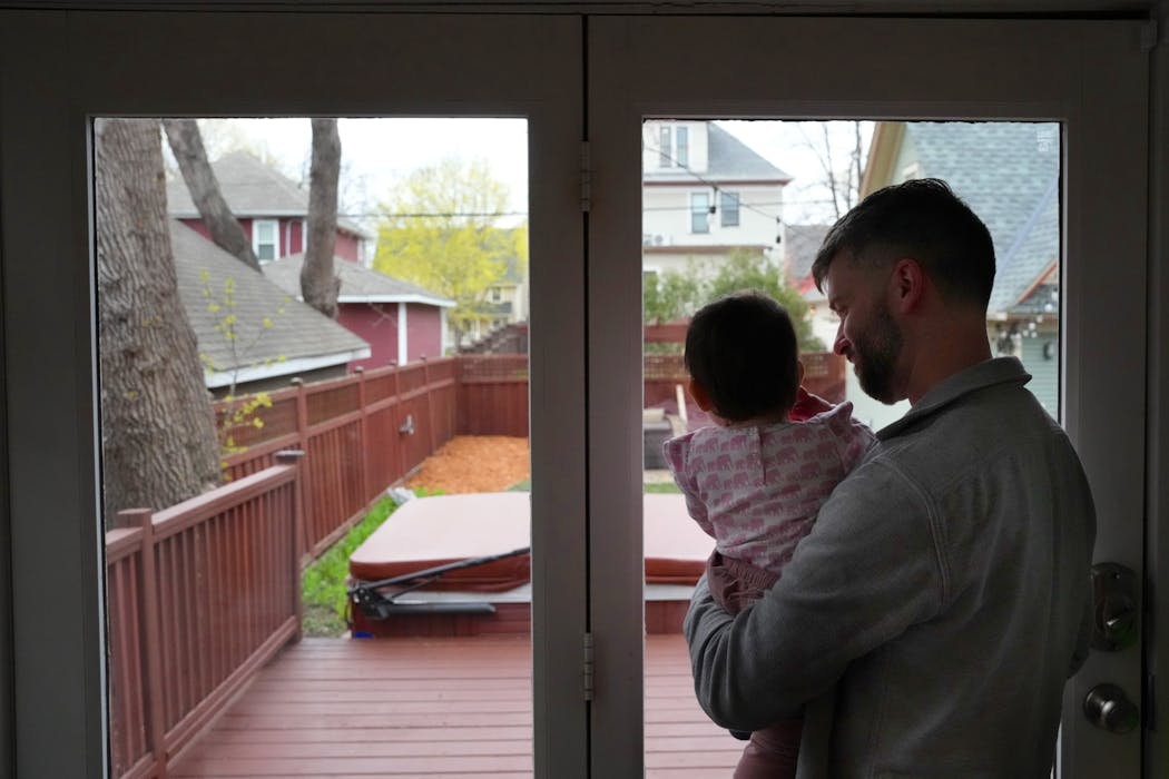 Tye Schulke holds his daughter Esme, 1, on Friday, the last night living together in a home he and his wife co-purchased with friends in 2017.