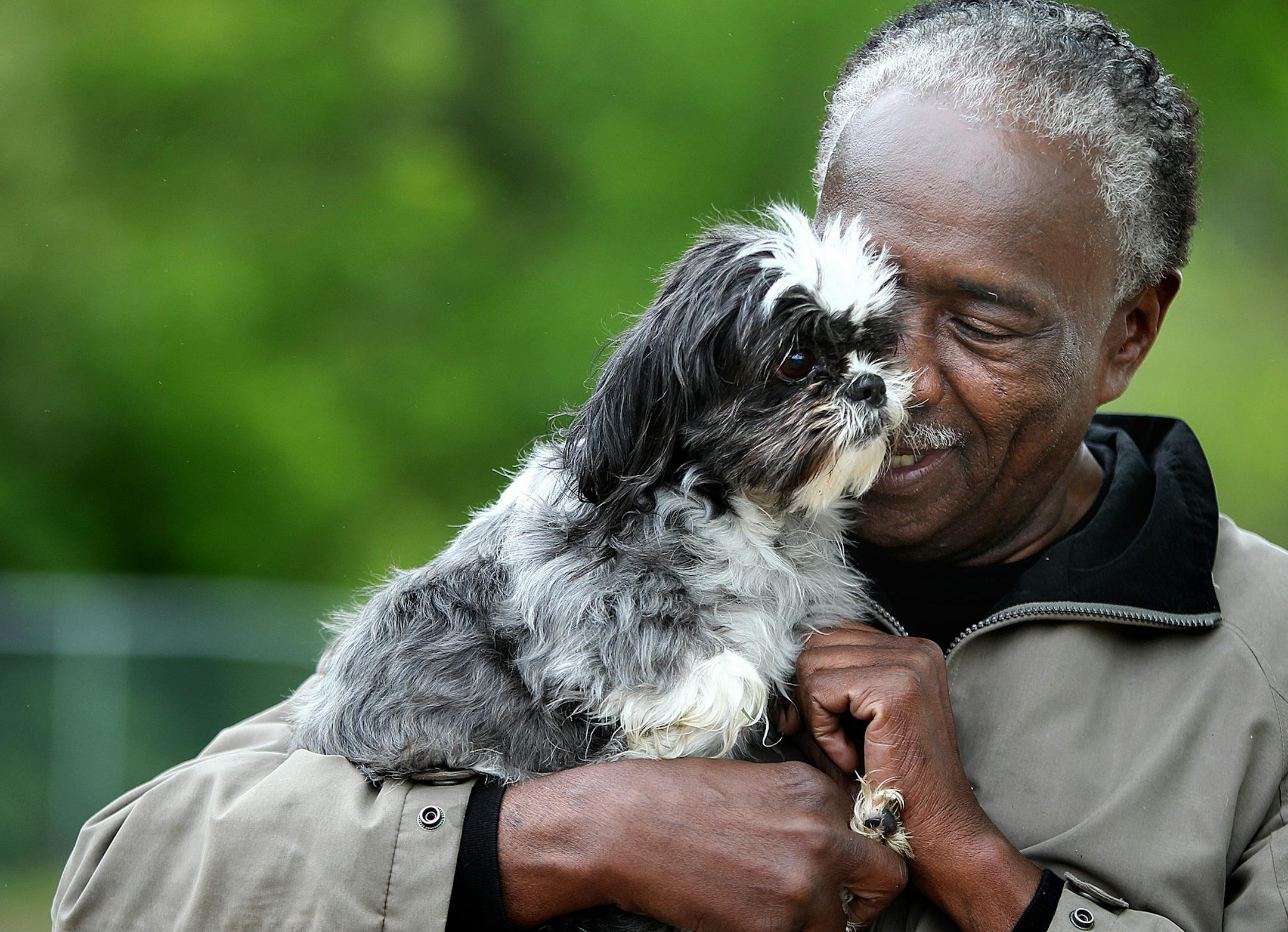Isaac Ward cuddled with "Baby" at Bassett Creek Dog Park, Tuesday, May 28, 2013 in Crystal, MN. Ward brought suit to the Bloomington Police after he was beaten in 2009 after an assault that was triggered by a dispute with an animal control officer at a dog park in Bloomington. (ELIZABETH FLORES/STAR TRIBUNE) ELIZABETH FLORES • eflores@startribune.com