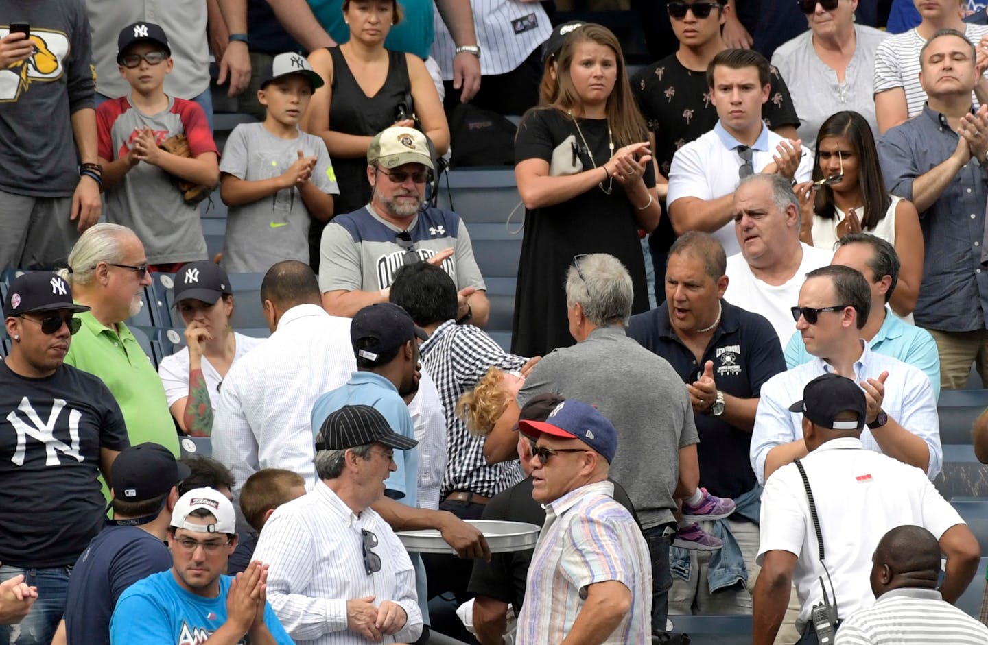 Baseball fans reacts as a young girl is carried out of the seating area after being hit by a line drive during the fifth inning of a baseball game between the New York Yankees and Minnesota Twins, Wednesday, Sept. 20, 2017, at Yankee Stadium in New York. (AP Photo/Bill Kostroun)