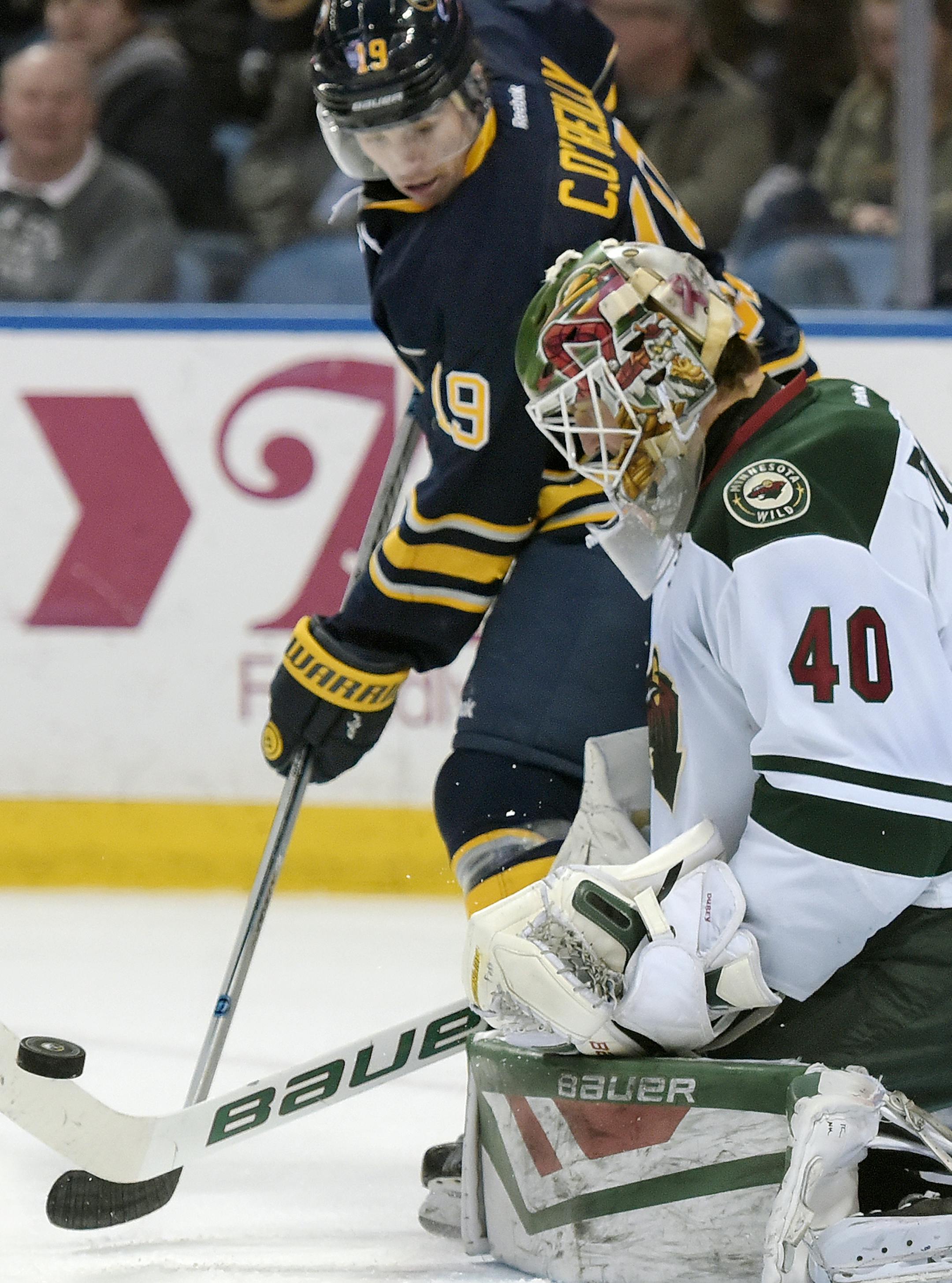Buffalo Sabres center Cal O'Reilly (19) looks to deflect the puck alongside Minnesota Wild goaltender Devan Dubnyk (40) during the third period of an NHL hockey game, Saturday, March 5, 2016, in Buffalo, N.Y. Minnesota won 3-2 in a shootout. (AP Photo/Gary Wiepert) ORG XMIT: MIN2016031422543869