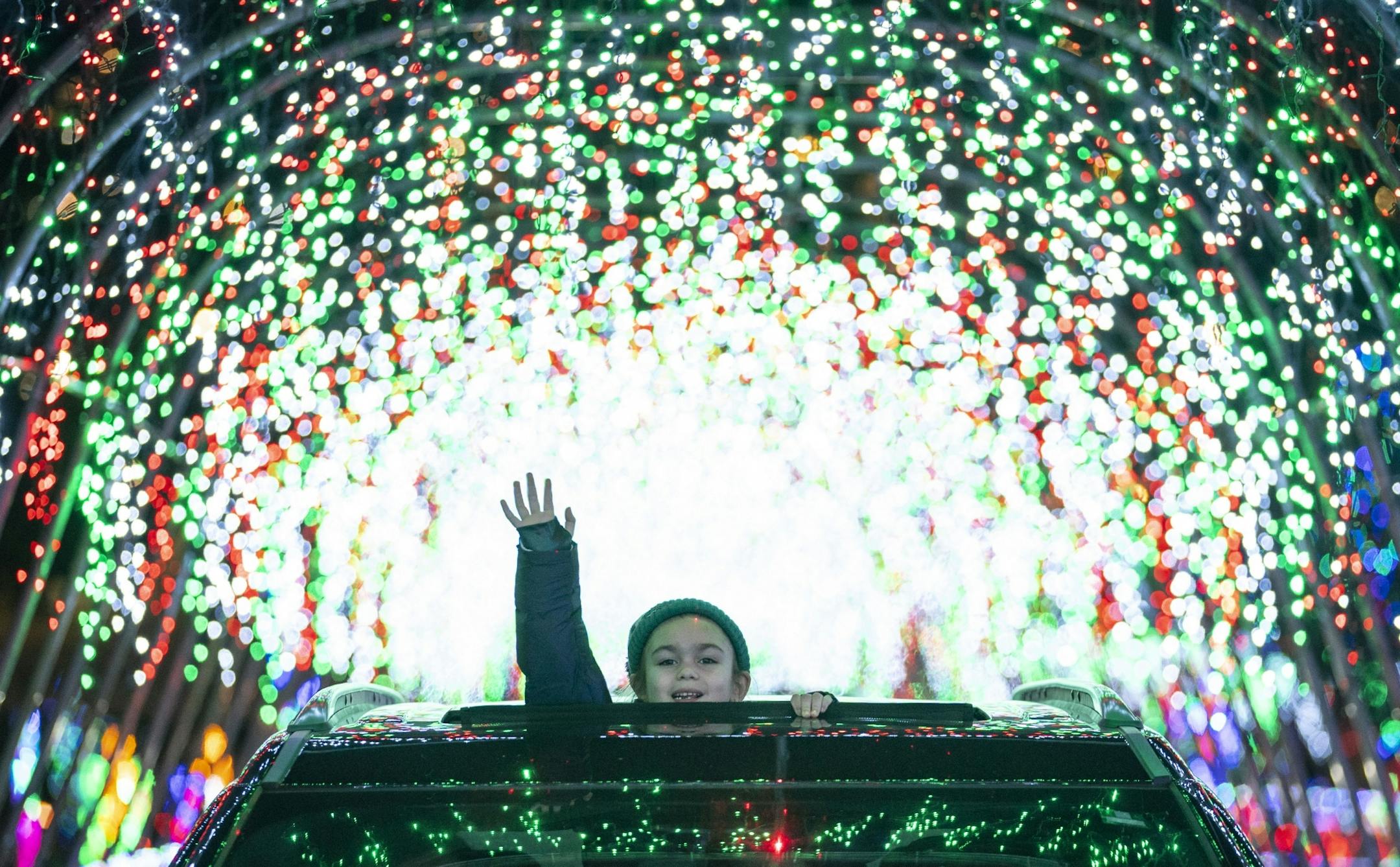 Lilian Reing, 6, from Cook, Minn. stuck her head out of the sunroof as her family drove through the first tunnel of lights.