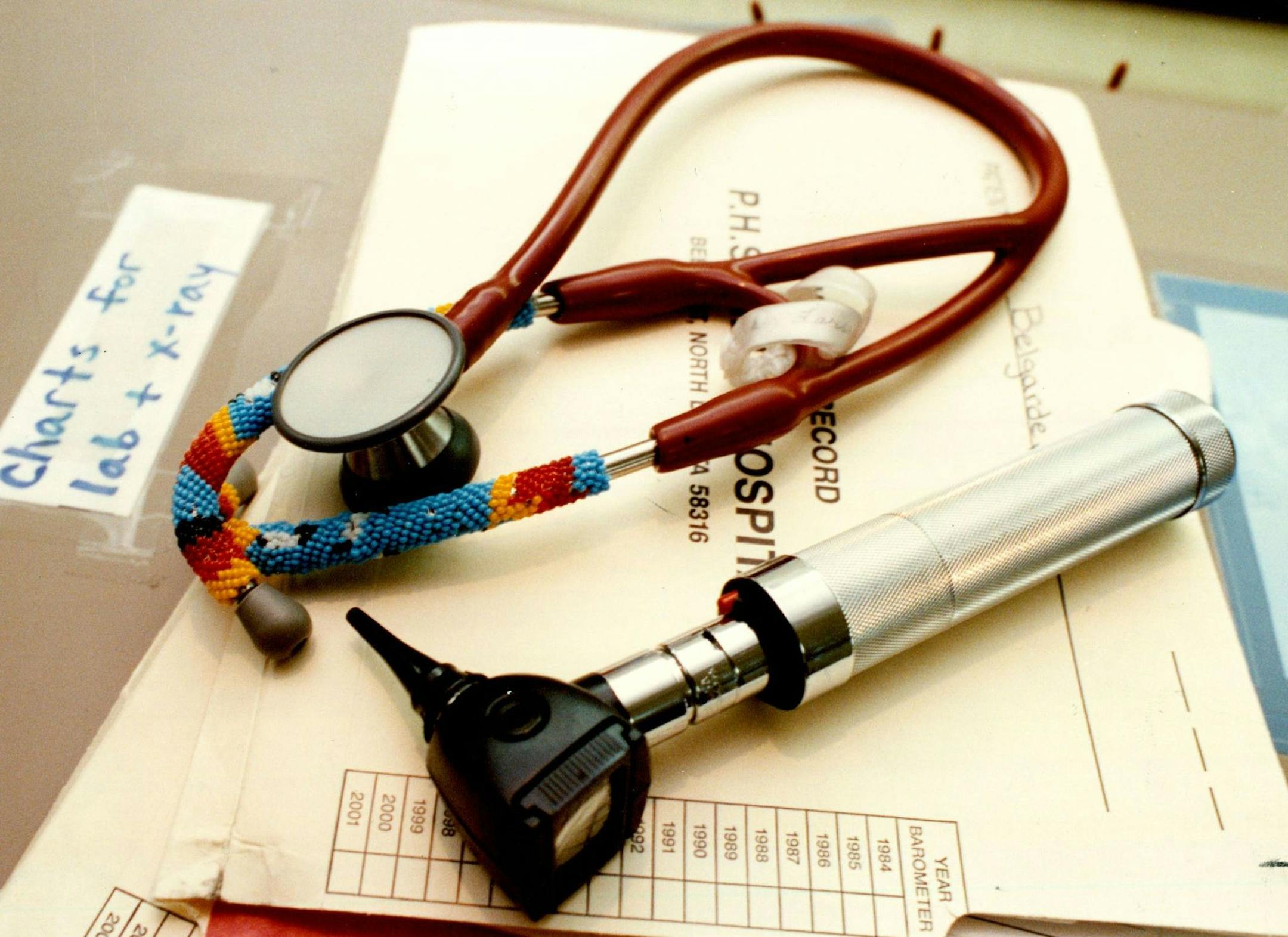 July 07, 1991 Dr Richard Larson's beaded stethoscope and otoscope lay on medical records on a desk in the emergency room of the Indian heath Service hospital on the Turtle Mountain Reservation in Belcourt, N.D. Dr. Richard Larson's beaded stethoscope lays on a pile of medical records on emergency room desk.. he Levy about sty of Stethoscope.