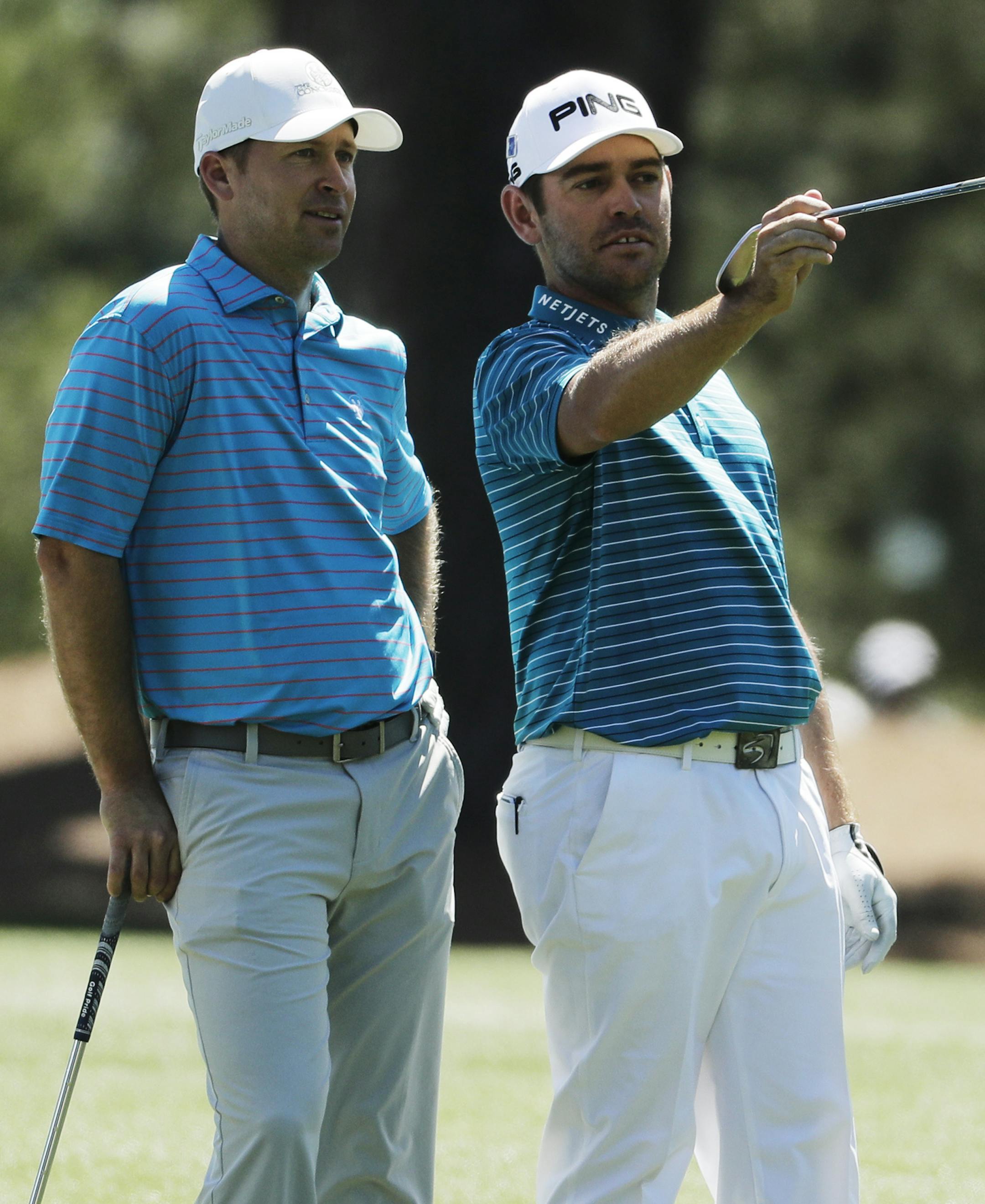Louis Oosthuizen, right, of South Africa, gives Amateur Sammy Schmitz advice on the 15th hole during a practice round for the Masters golf tournament, Monday, April 4, 2016, in Augusta, Ga. (AP Photo/Chris Carlson)