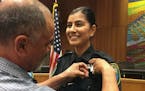 Merced Corona pinned his daughter Natalie Corona's badge on her uniform during a swearing-in ceremony in August 2018 in Davis, Calif.
