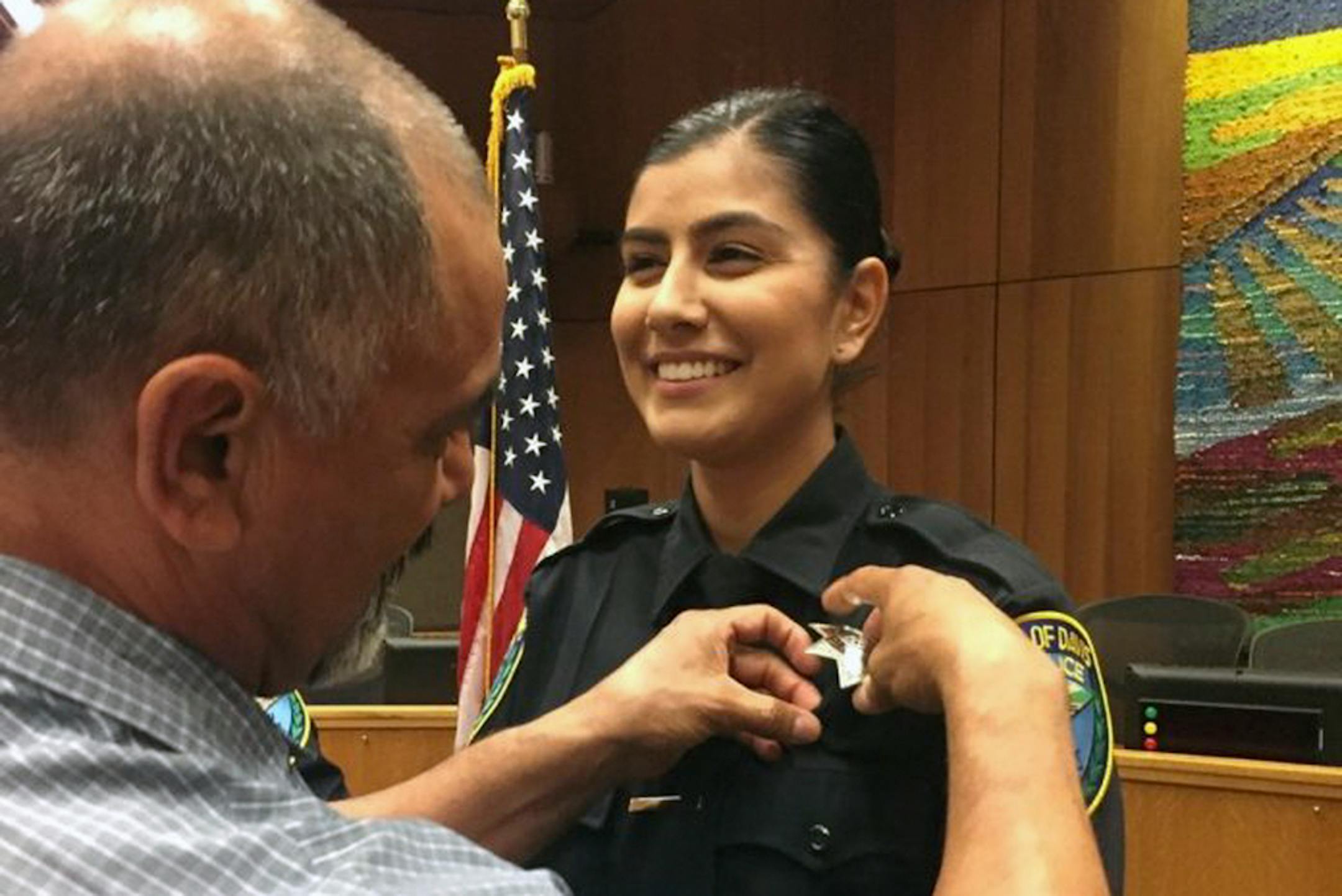 Merced Corona pinned his daughter Natalie Corona's badge on her uniform during a swearing-in ceremony in August 2018 in Davis, Calif.