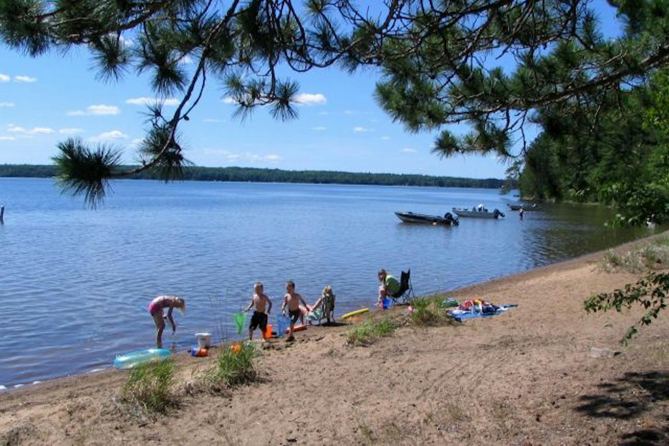 A family sets up on a stretch of beach on Trout Lake that is accessible by boat.