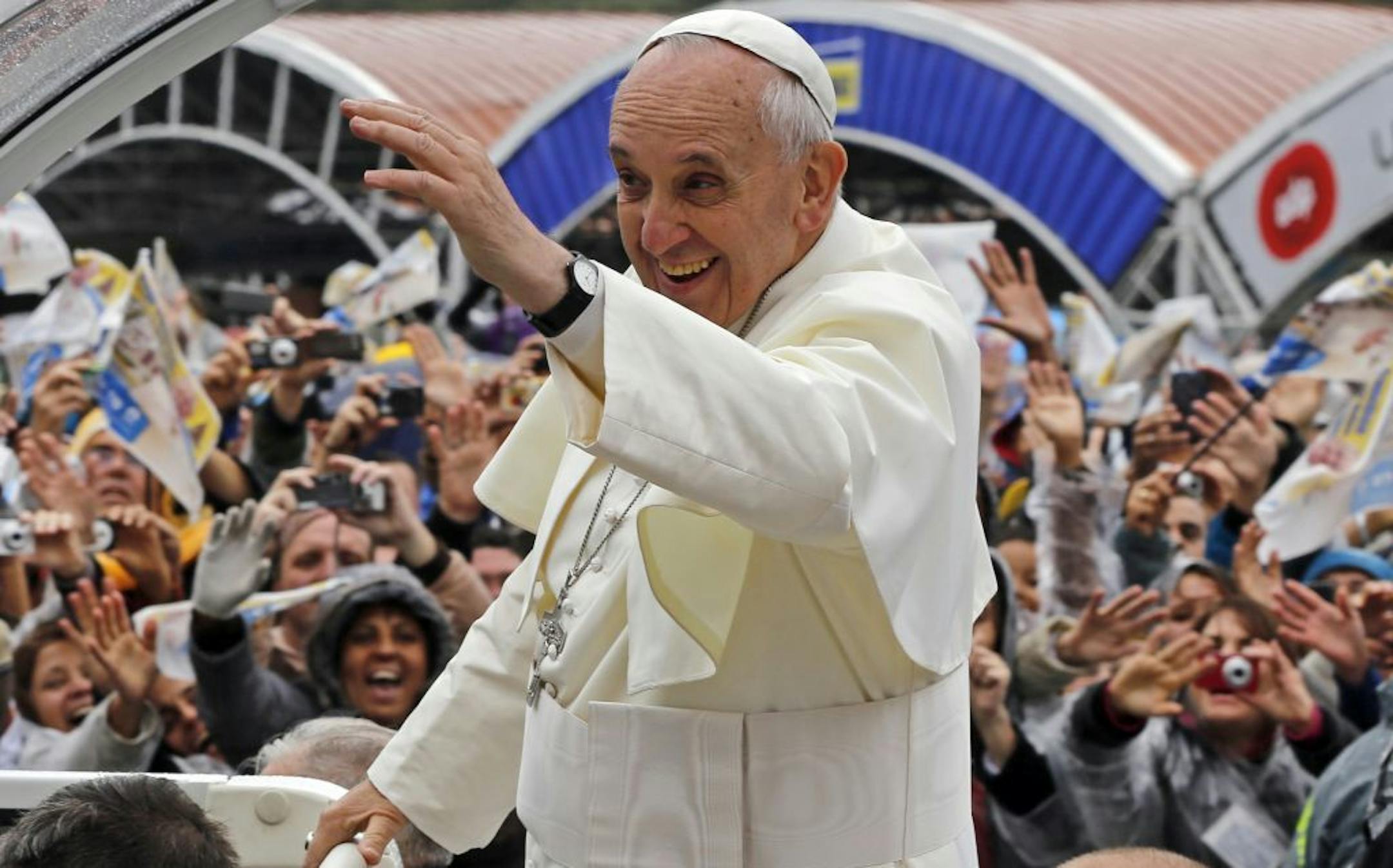 Pope Francis waves to pilgrims from his popemobile as he arrives to the Aparecida Basilica in Aparecida, Brazil, Wednesday, July 24, 2013. Tens of thousands of faithful flocked to the tiny town of Aparecida, tucked into an agricultural region halfway between Rio de Janeiro and Sao Paulo, where he is to celebrate the first public Mass of his trip in a massive basilica dedicated to the nation's patron saint.