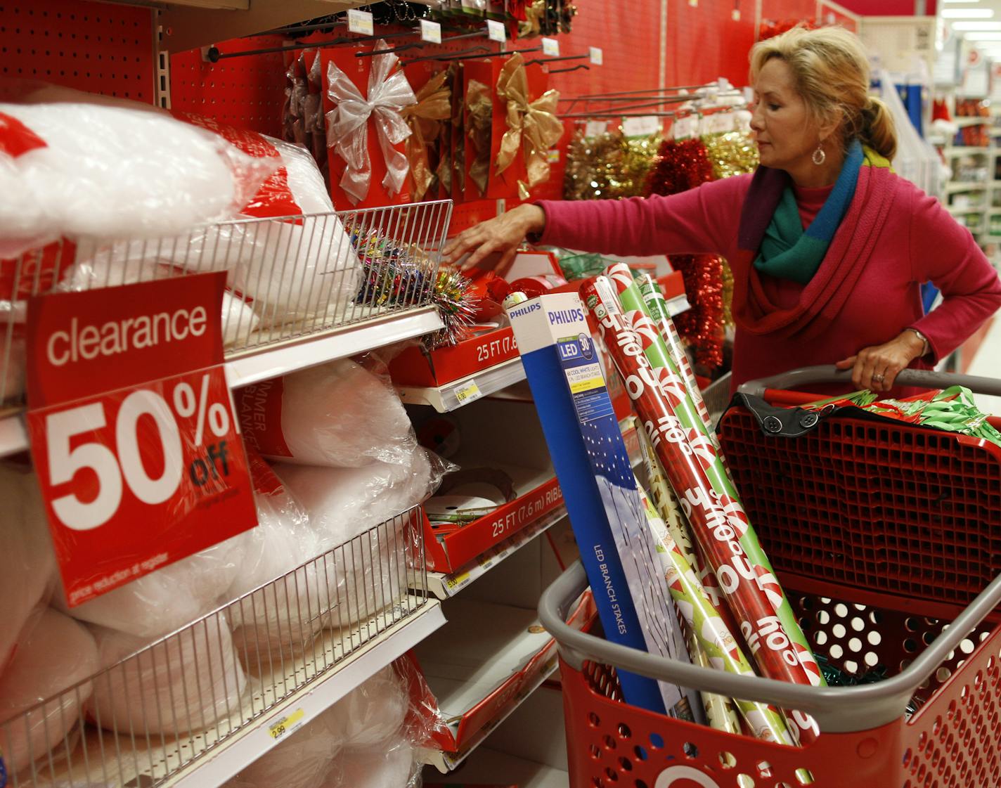 Holly Bryan stocks up on Christmas wrapping paper and other holiday items while shopping for after Christmas deals at a Target store in Chattanooga, Tenn.