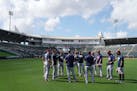 Twins position players huddled in the outfield during spring training in February.