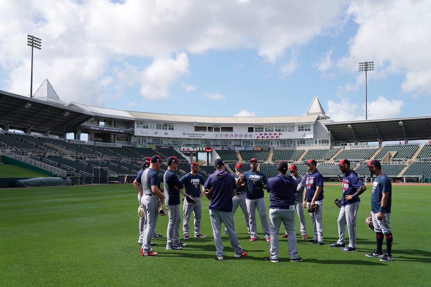 Twins position players huddled in the outfield during spring training in February.