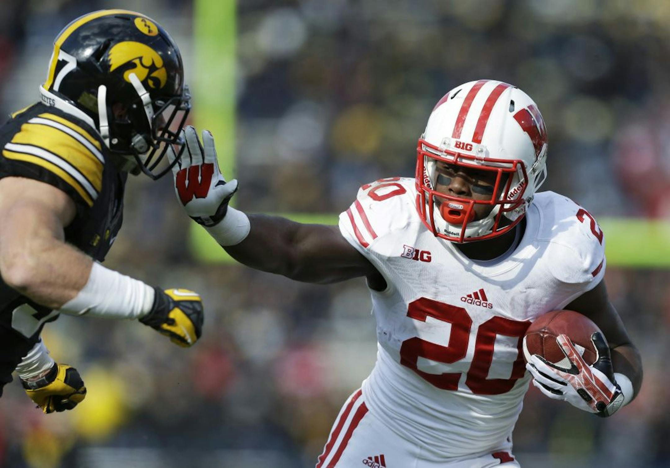 Wisconsin running back James White, right, runs from Iowa defensive back John Lowdermilk during the second half of an NCAA college football game, Saturday, Nov. 2, 2013, in Iowa City, Iowa. White rushed for 132 yards in Wisconsin's 28-9 win.