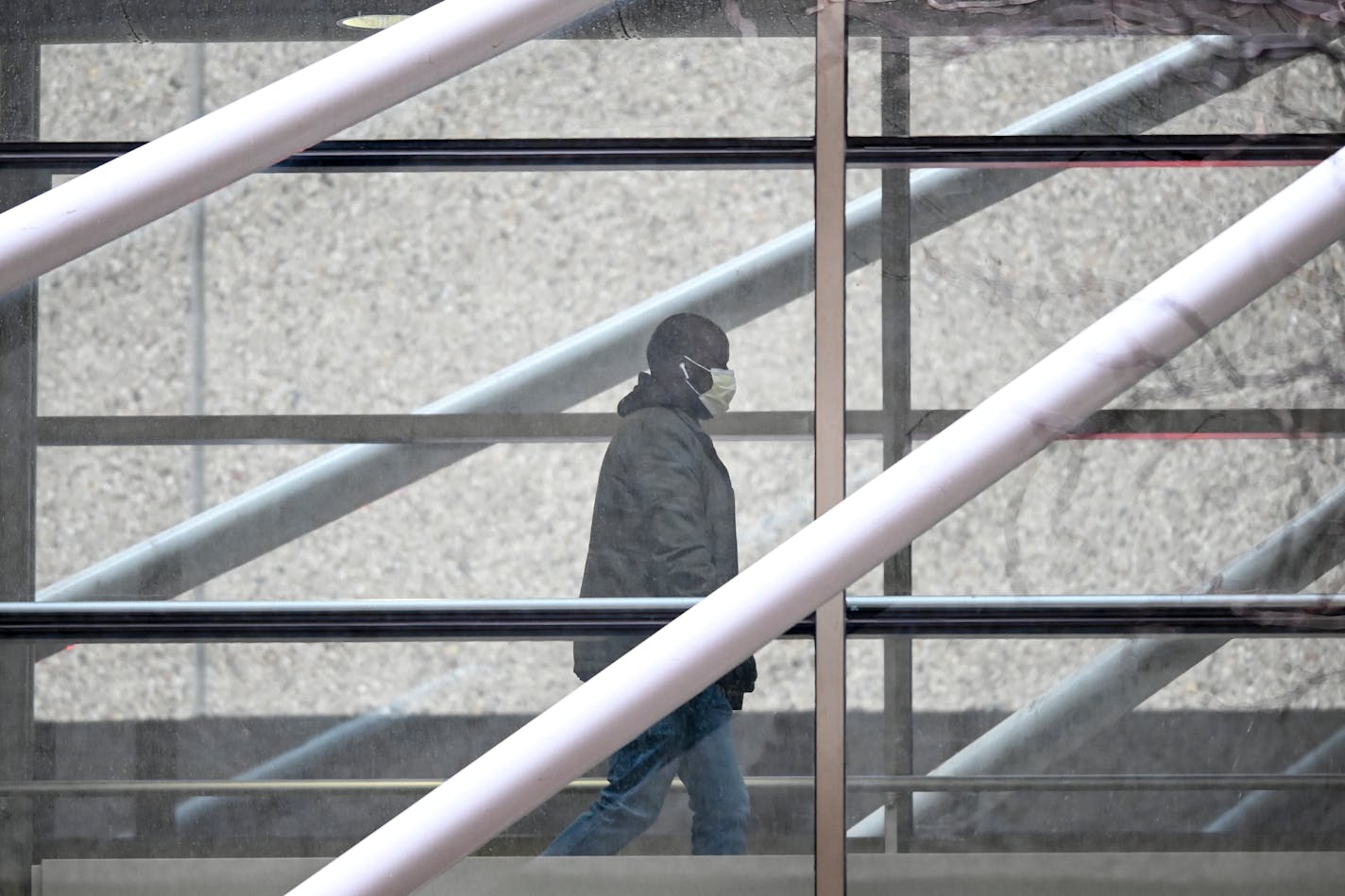 A man, donning a surgical mask, walked through the skyway attached to HCMC Wednesday afternoon.