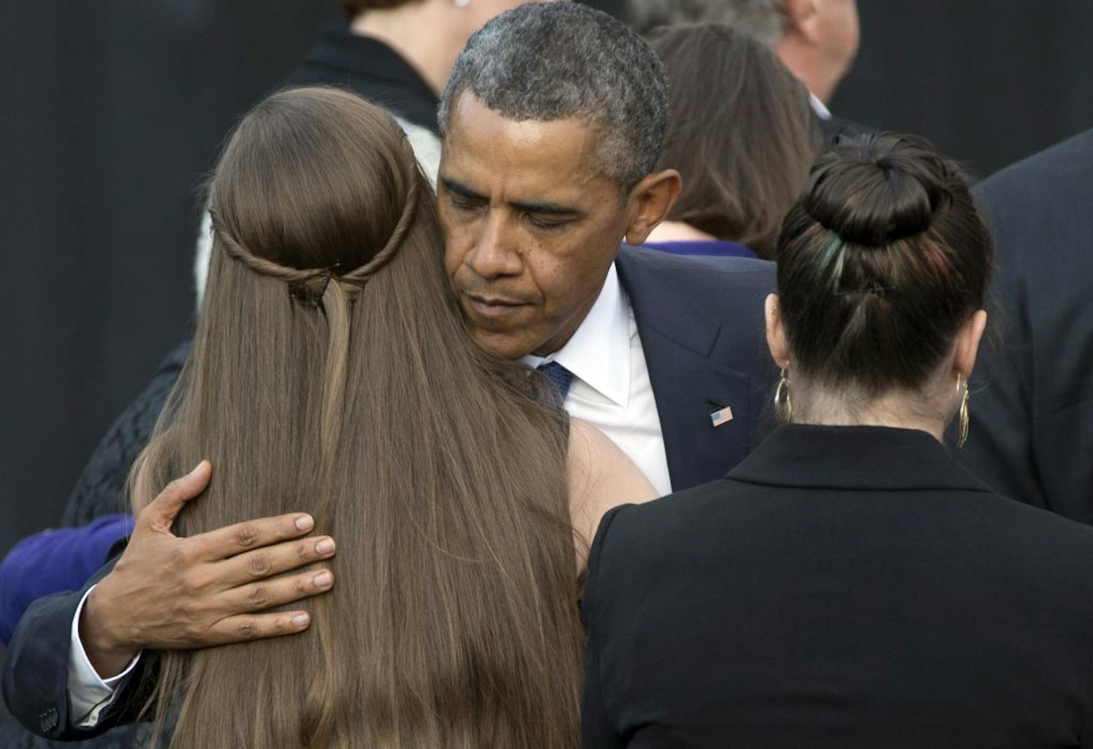President Barack Obama comforts family members of victims during a memorial service for the victims of the Washington Navy Yard shooting at Marine Barracks Washington, Sunday, Sept. 22, 2013, in Washington. A gunman killed 12 people in the Navy Yard on Monday, Sept. 16, 2013, before being fatally shot in a gun battle with law enforcement.