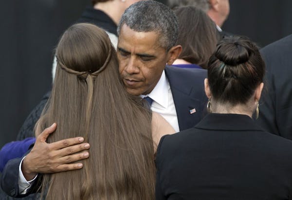 President Barack Obama comforts family members of victims during a memorial service for the victims of the Washington Navy Yard shooting at Marine Bar