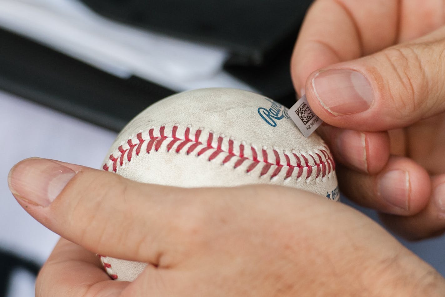 AUTH090114 * 20035859A * 964956 * Mark Vancleave - mark.vancleave@startribune.com * Twins authenticator Steven Bantle collects and tags game memorabilia during a Twins-Royals game Sun. Aug. 17, 2014 at Target Field. [Bantle attaches a holographic authentication tag to each item recovered. The tag contains a unique barcode and serial number associated with details of the item's significance.]