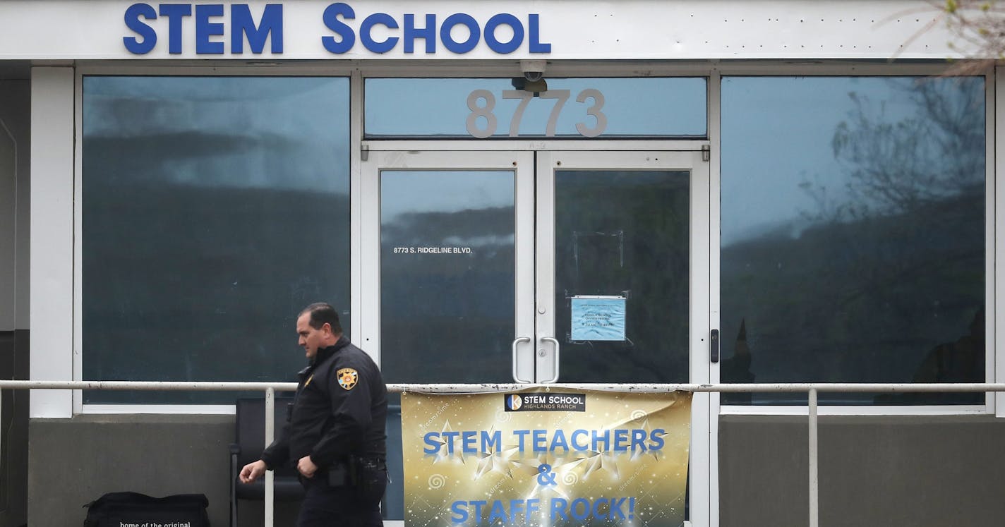 A Douglas County, Colo., Sheriffs Department deputy walks past the doors to the STEM Highlands Ranch school early Wednesday, May 8, 2019, in Highlands Ranch, Colo. Two high school students used at least two handguns in a fatal Tuesday shooting at the charter school authorities said Wednesday. (AP Photo/David Zalubowski)