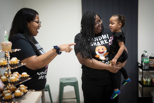 Taylor Richardson, left, smiles as her mother Ruth Richardson, executive director of Planned Parenthood North Central States, center, holds her grandd