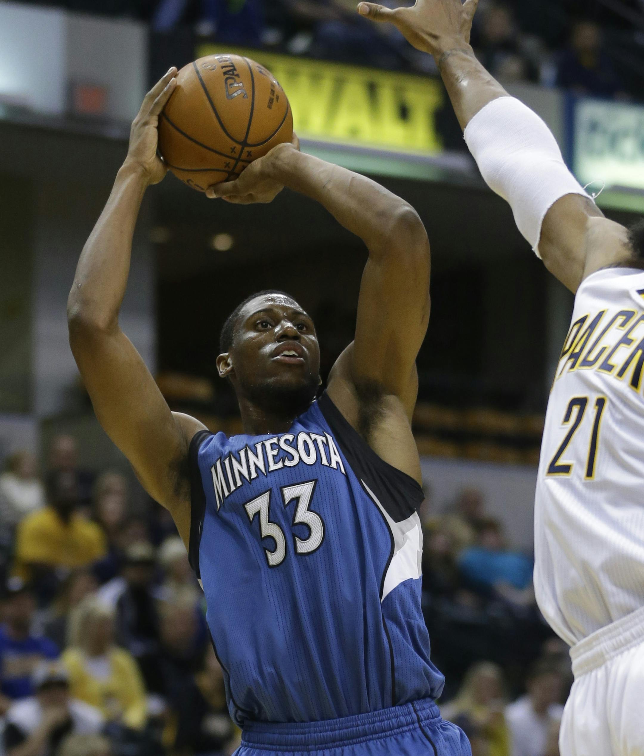 Minnesota Timberwolves forward Thaddeus Young, left, shoots over Indiana Pacers forward David West during the first half of a preseason NBA basketball game in Indianapolis, Tuesday, Oct. 7, 2014. (AP Photo/Michael Conroy)