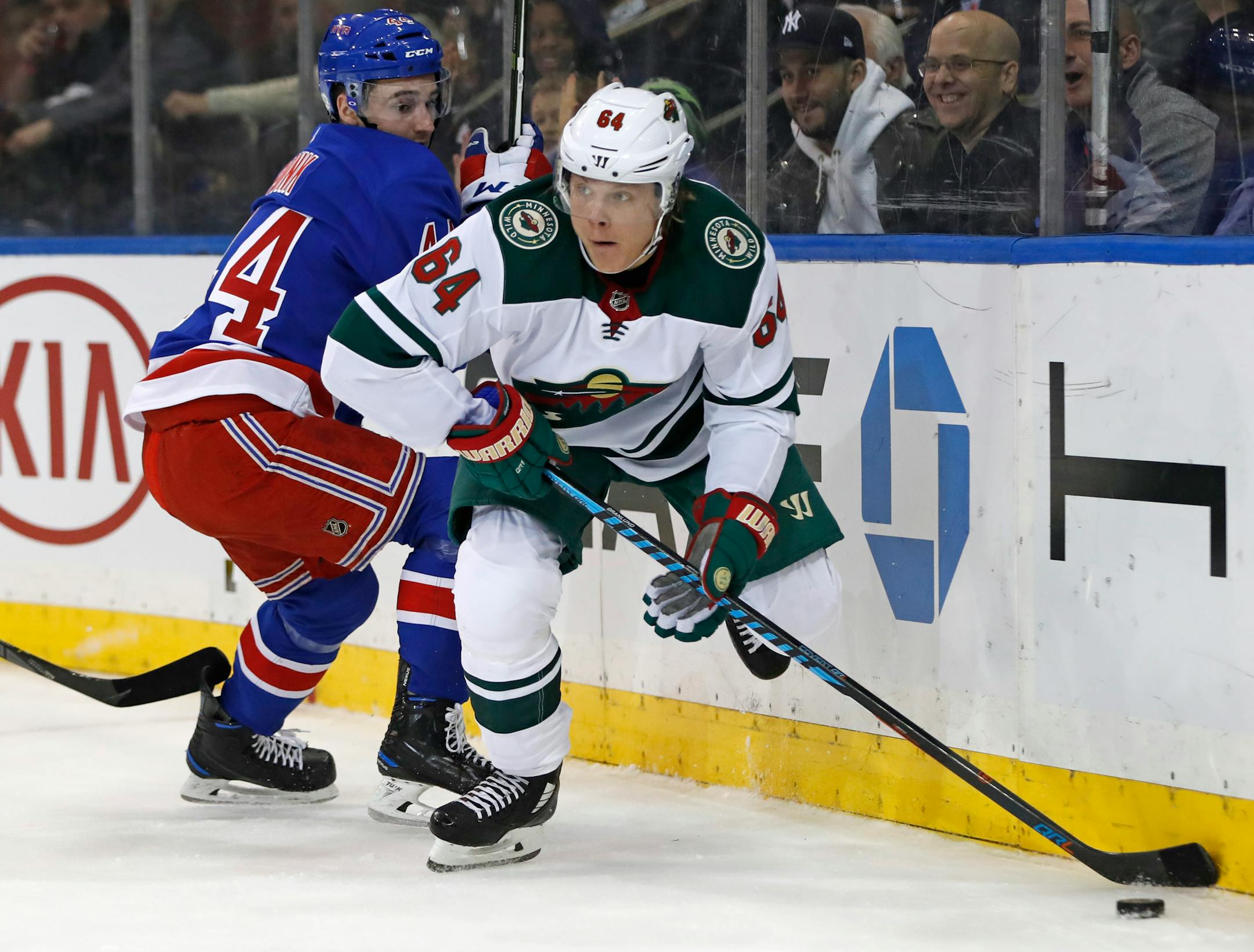 With New York Rangers defenseman Neal Pionk (44) looking on, Minnesota Wild right wing Mikael Granlund (64) looks to pass during the first period of an NHL hockey game in New York, Friday, Feb. 23, 2018. (AP Photo/Kathy Willens)
