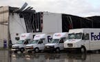 FedEx trucks sit outside a damaged FedEx facility after a tornado in Portage, Mich., Tuesday, May 7, 2024. (Brad Devereaux/Kalamazoo Gazette via AP)