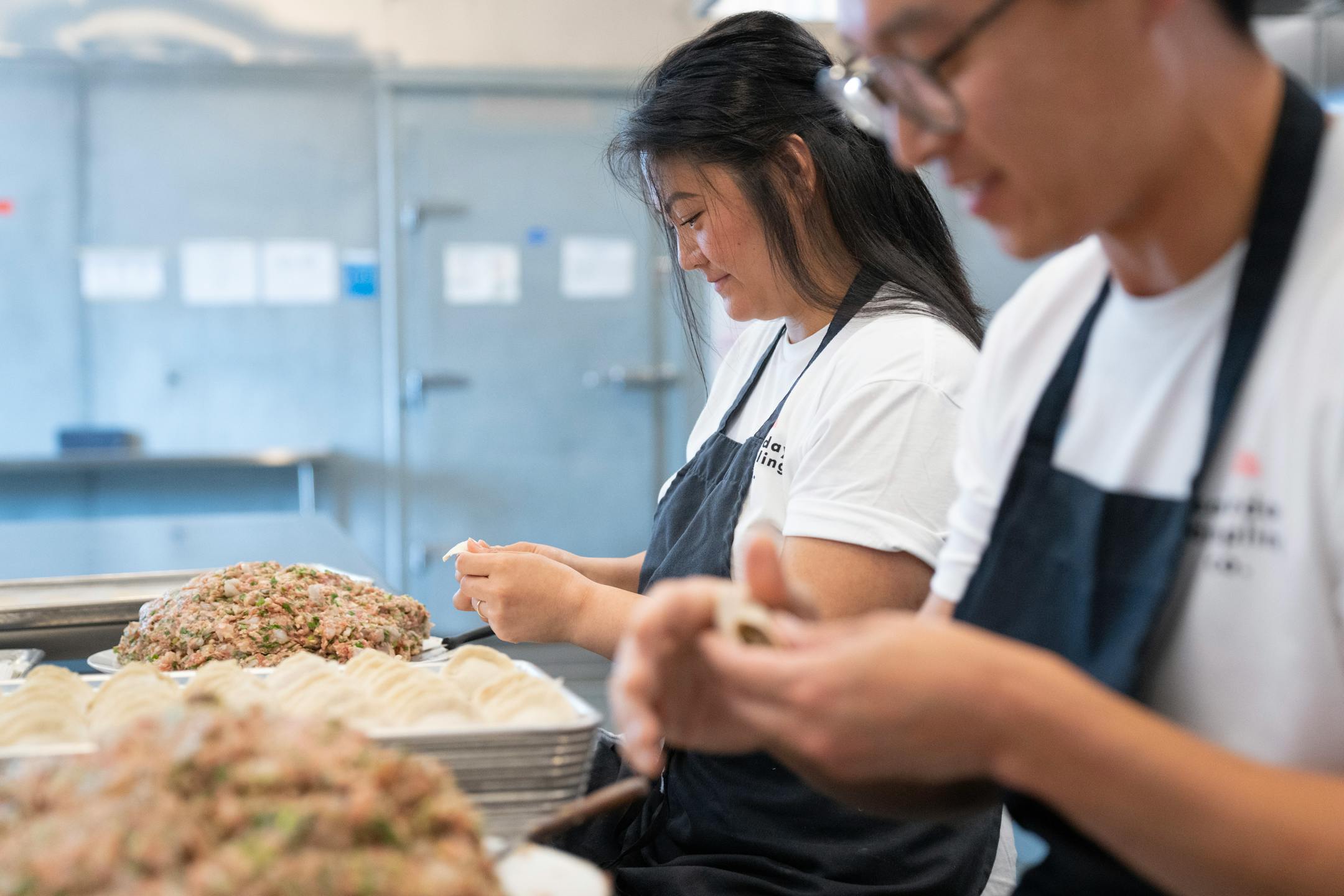 Linda Cao and Peter Bian, co-founders of Saturday Dumpling Co., left to right, assemble pork, shrimp and chive dumplings Thursday, May 11, 2023, at Dots Gray Kitchen in Minneapolis.