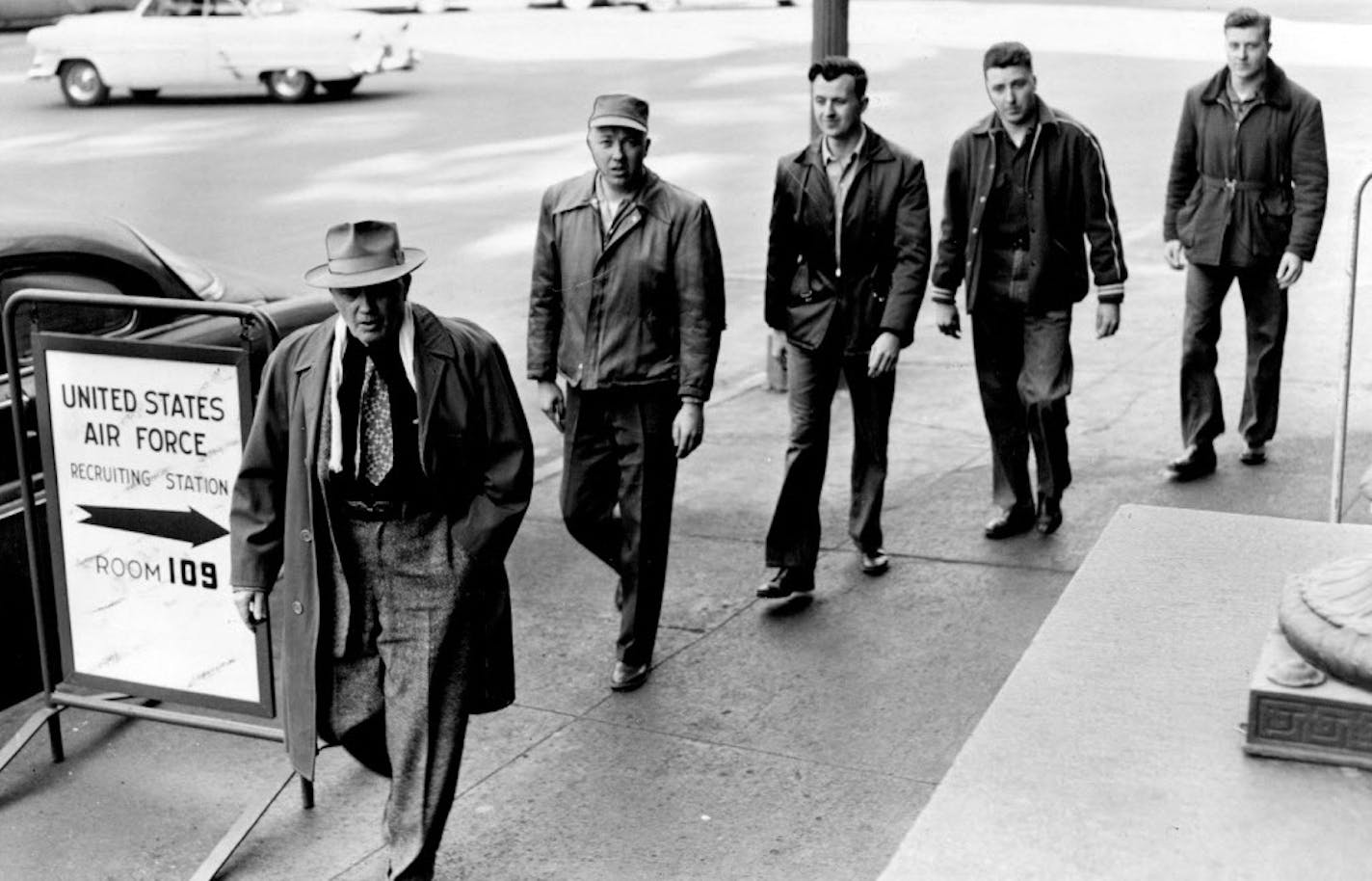 March 30, 1955 Off to Jail Again -- Minnesota's four Doty brothers surrendered Tuesday to the United States marshal in St. Paul to begin a second prison term for their defiance of military conscription. Above, they are leaving the federal courthouse on their way to Ramsey county jail, accompanied by their father, William (far left), a Bruno, Minn., farmer, who served a World War I prison term for his pacifist beliefs. The brothers, all sentenced to two years, are (left to right Joel. 28, Orin, 2