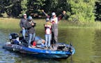 CORRECT CAPTION/USE THIS VERSION. Colby reacted to his catch Wednesday on Mantrap Lake, along with pro angler Scott Martin, right, and Colby's dad, Se