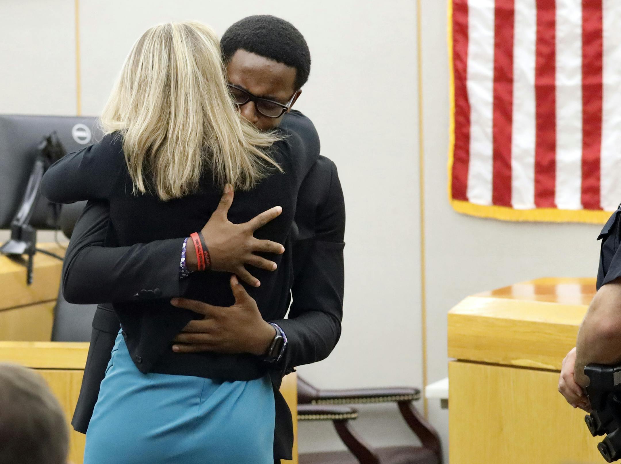 FILE - In this Oct. 2, 2019, file photo, Botham Jean's younger brother Brandt Jean hugs convicted murderer and former Dallas Police Officer Amber Guyger after delivering his impact statement to her after she was sentenced to 10 years in jail, in Dallas. The Institute for Law Enforcement Administration gave 18-year-old Brandt Jean an award Tuesday, Dec. 3, 2019, for his "display of empathy and forgiveness" toward Guyger. Brandt said at the ceremony that it was hard to accept an award from a polic