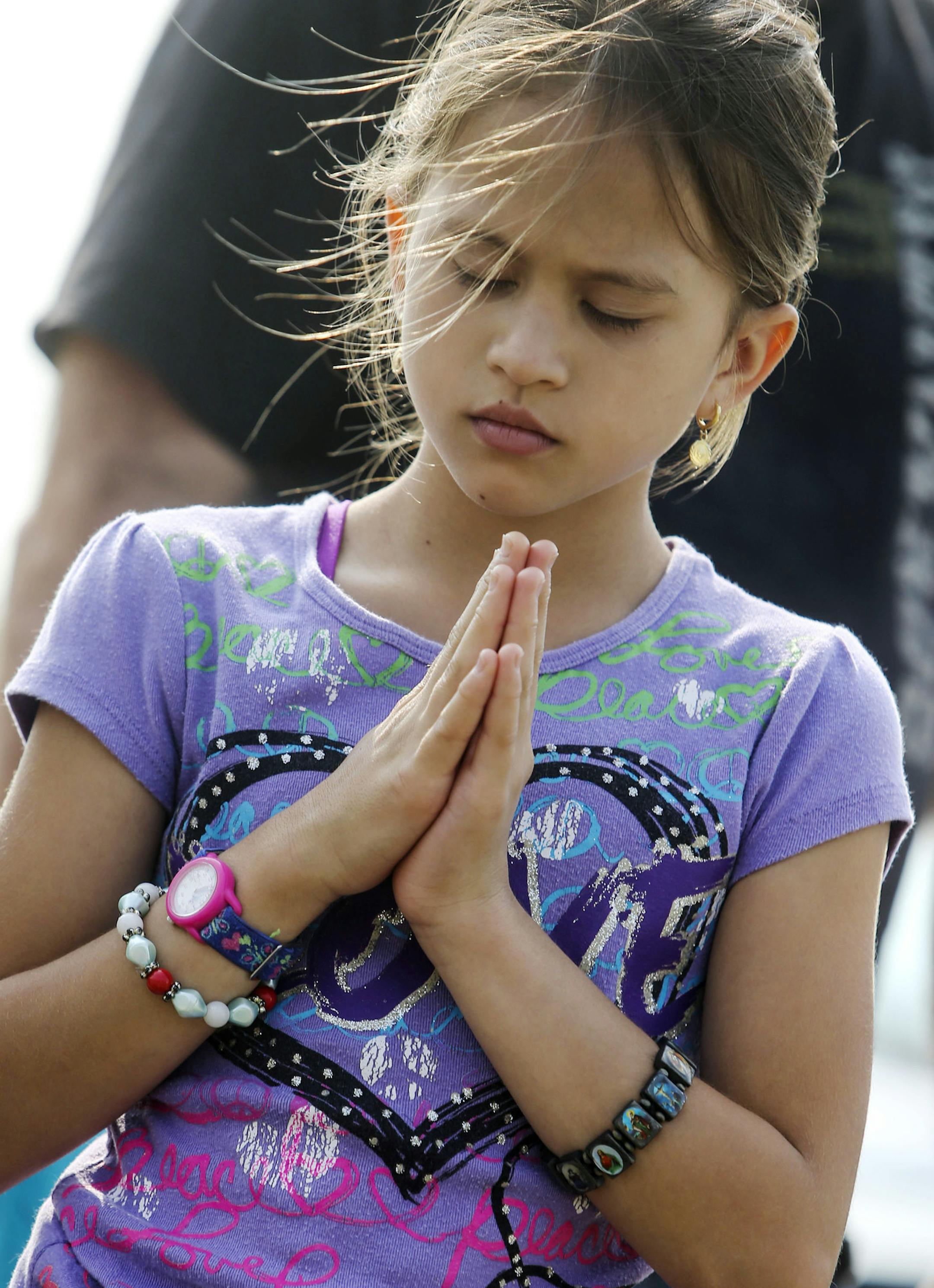 Maria Kaiser, 9, prays at the Memorial site.