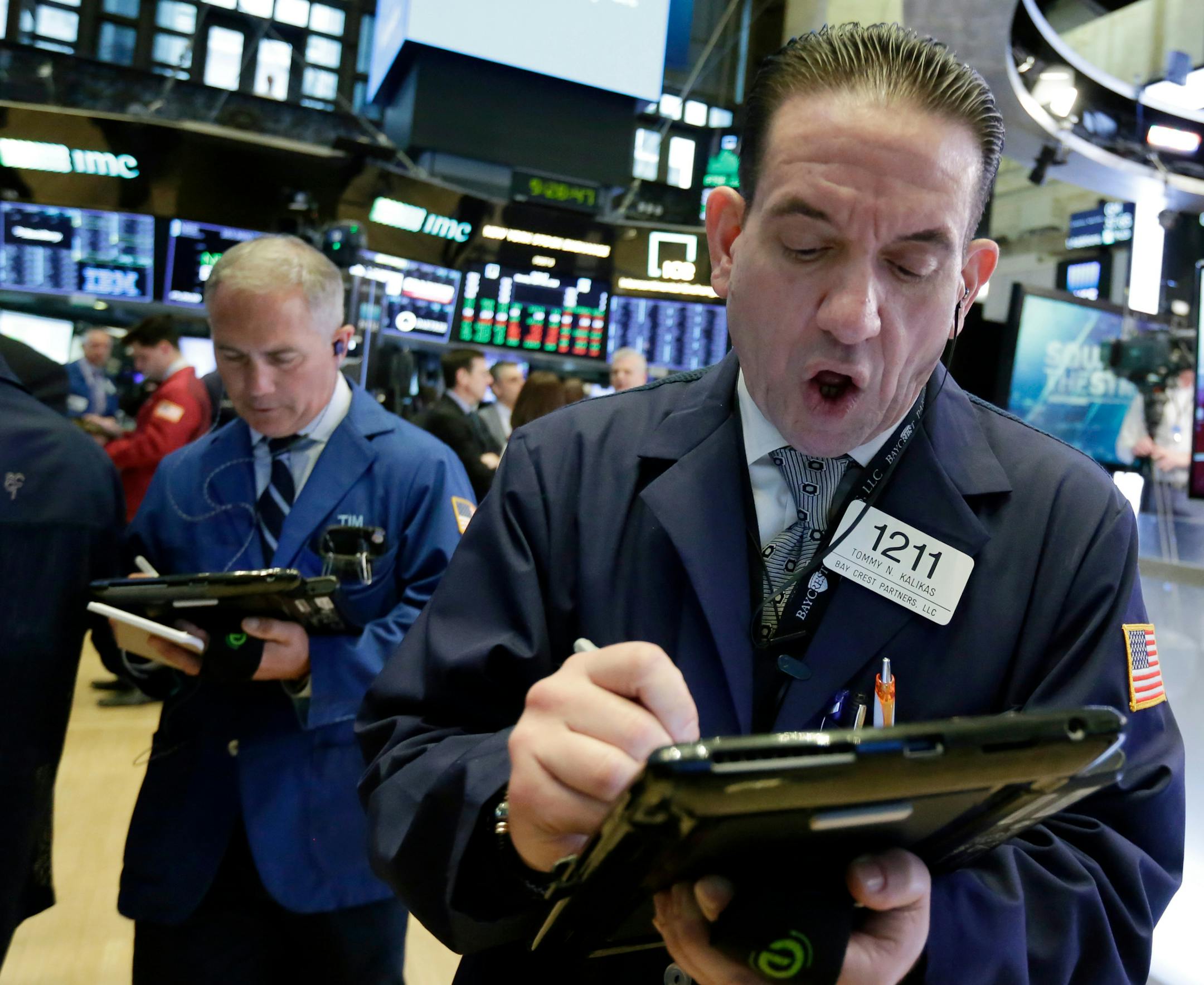 Trader Tommy Kalikas, right, works on the floor of the New York Stock Exchange, Monday, April 30, 2018. A burst of corporate deals and strong earnings reports helped push U.S. stock indexes higher in early trading Monday. (AP Photo/Richard Drew)