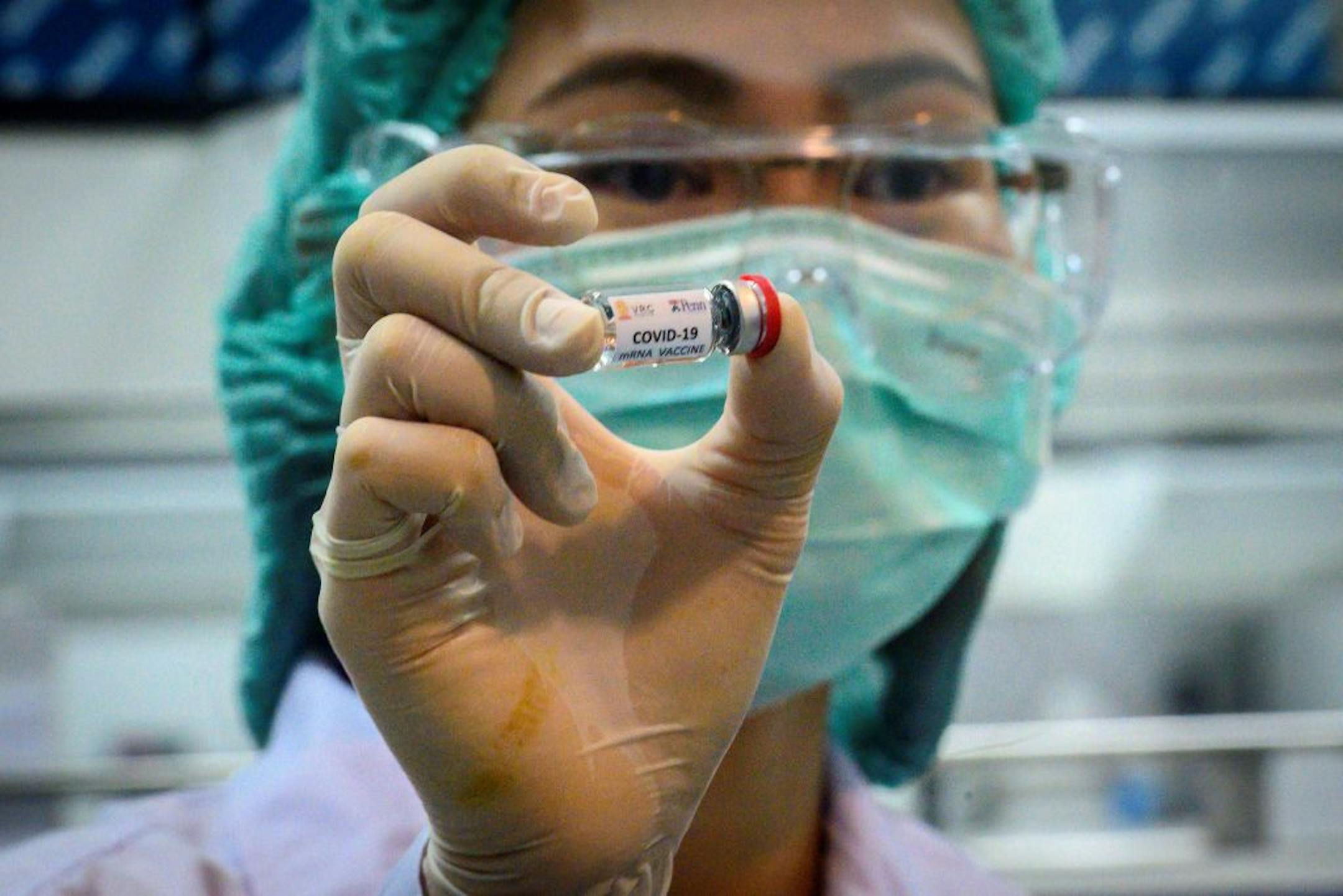 This picture taken on May 23, 2020 shows a laboratory technician holding a dose of a COVID-19 novel coronavirus vaccine candidate ready for trial on monkeys at the National Primate Research Center of Thailand at Chulalongkorn University in Saraburi.