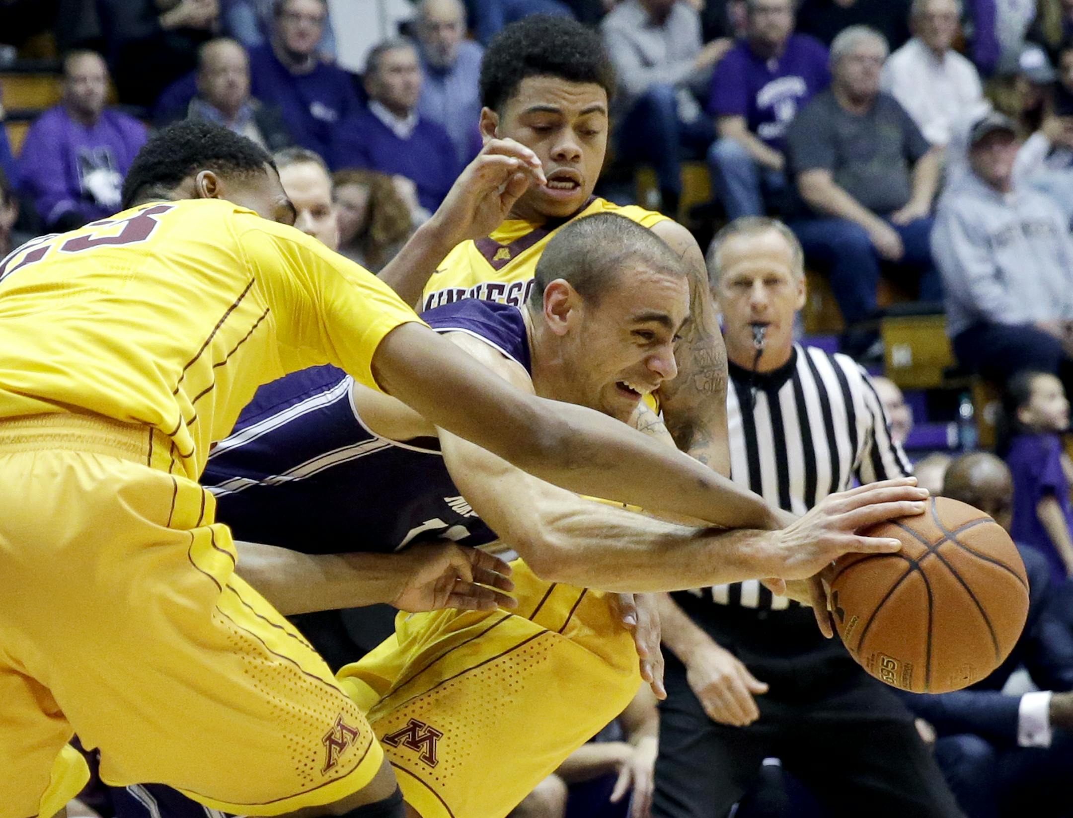 Northwestern guard Tre Demps, center, controls the ball between Minnesota forward Charles Buggs, left, and guard Nate Mason during the first half of an NCAA college basketball game on Thursday, Feb. 4, 2016, in Evanston, Ill. (AP Photo/Nam Y. Huh)