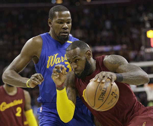 Cleveland Cavaliers' LeBron James (23) drives past Golden State Warriors' Kevin Durant (35) in the first half of an NBA basketball game, Sunday, Dec. 