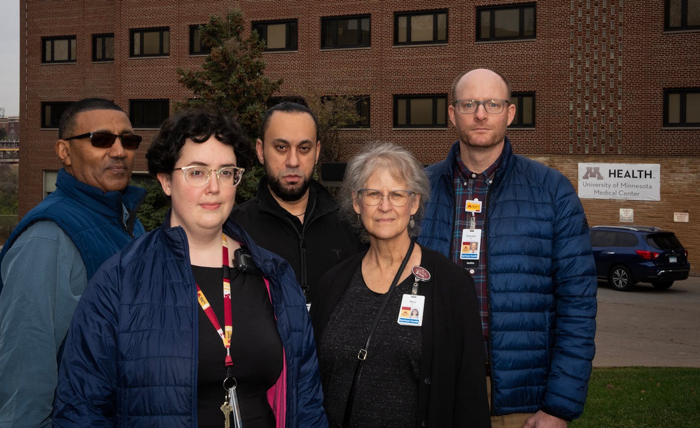 Chaplains recently laid off stand for a portrait outside a University of Minnesota health clinic in Minneapolis, Minn., on Wednesday, Nov. 8, 2023. Standing from left, Alem Asmelash, Carolyn Browender, Tamer Abdelaziz, Mary Shaffer and Brandon Newton.