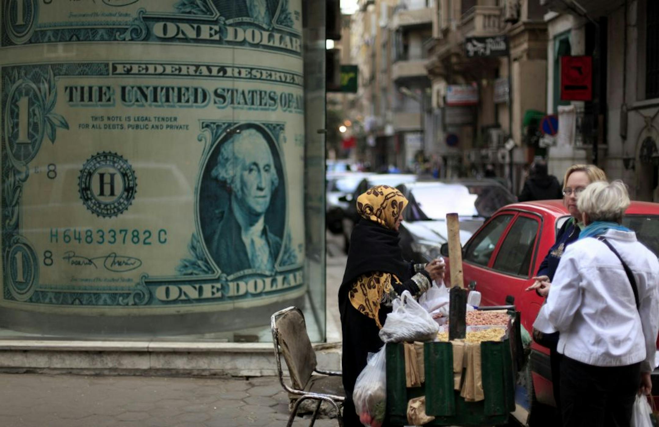A vendor worked outside a currency exchange office in Cairo. The turbulence of the past month and expected austerity measures have prompted some to hoard dollars.