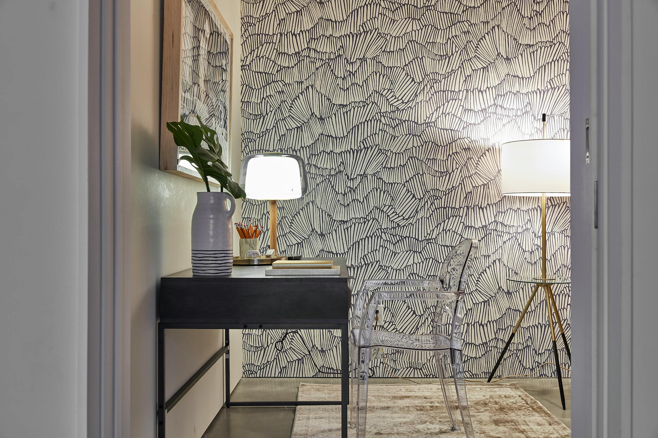 Patterned gray and white wallpaper highlights one wall of a small room.
