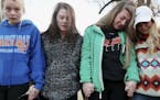 Students Brooklyn Boyce, left, and Katlyn Gamble cry as they hold hands with other Marshall County High School classmates during a prayer vigil for th