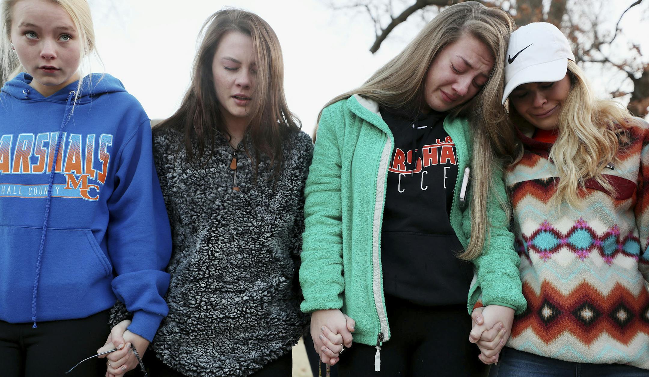 Students Brooklyn Boyce, left, and Katlyn Gamble cry as they hold hands with other Marshall County High School classmates during a prayer vigil for their classmates Wednesday, Jan. 24, outside at Paducah Tilghman High School. Two students were killed and 18 were injured Tuesday morning in a shooting at Marshall County High School in Benton, Ky. (Matt Stone/The Courier-Journal via AP)