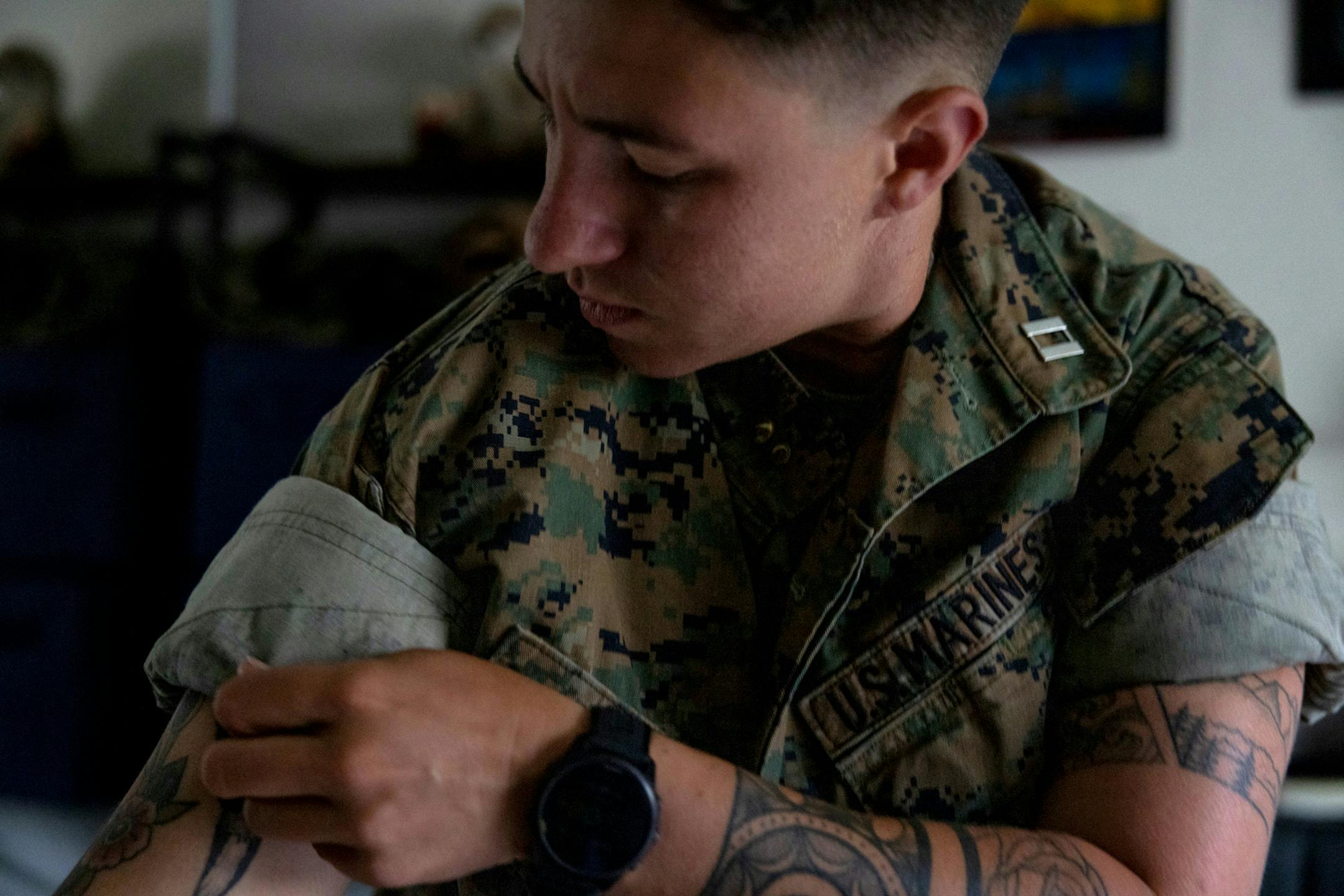 Marine Capt. Sye Savoie gets dressed for work on Tuesday, June 24, 2025, in Oceanside, California. Savoie has been a Marine for over six years and has opted to remain in the service until they're involuntarily separated following the Trump administration's ban on transgender people in the military.