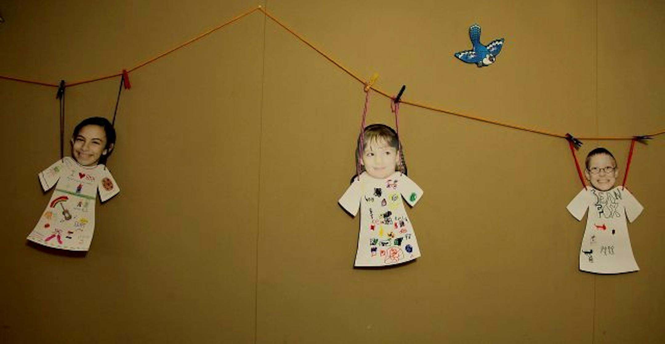 Photos of students hang on the wall outside the classroom.