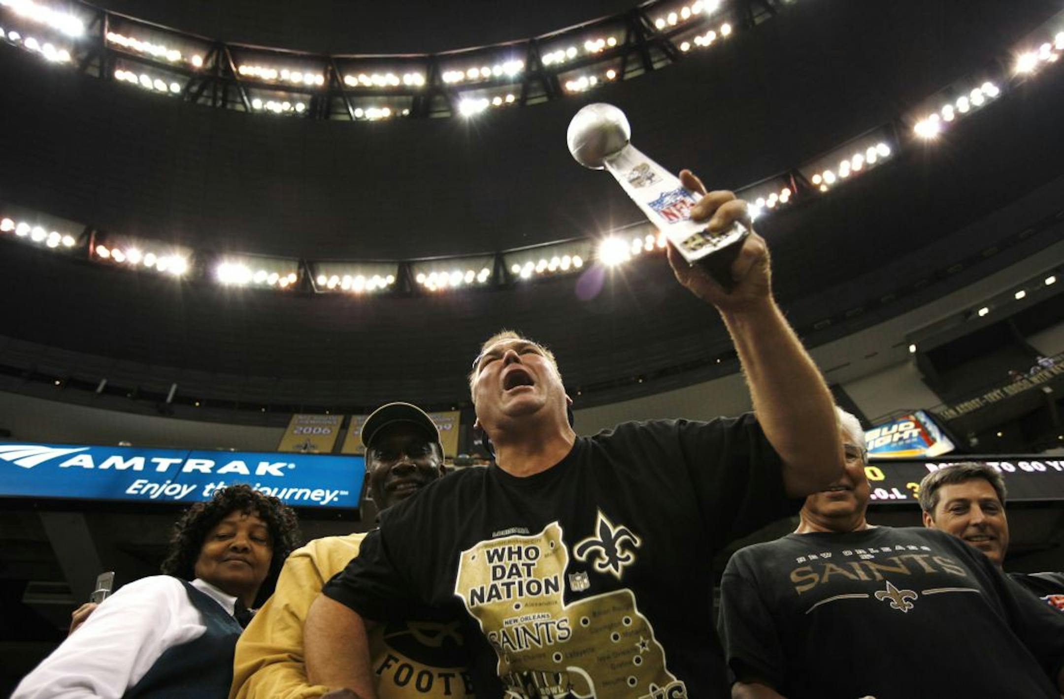 A Saints fan was happy with his team as he holds up a personal version of the Vince Lombardy Super Bowl Trophy at the Superdome.