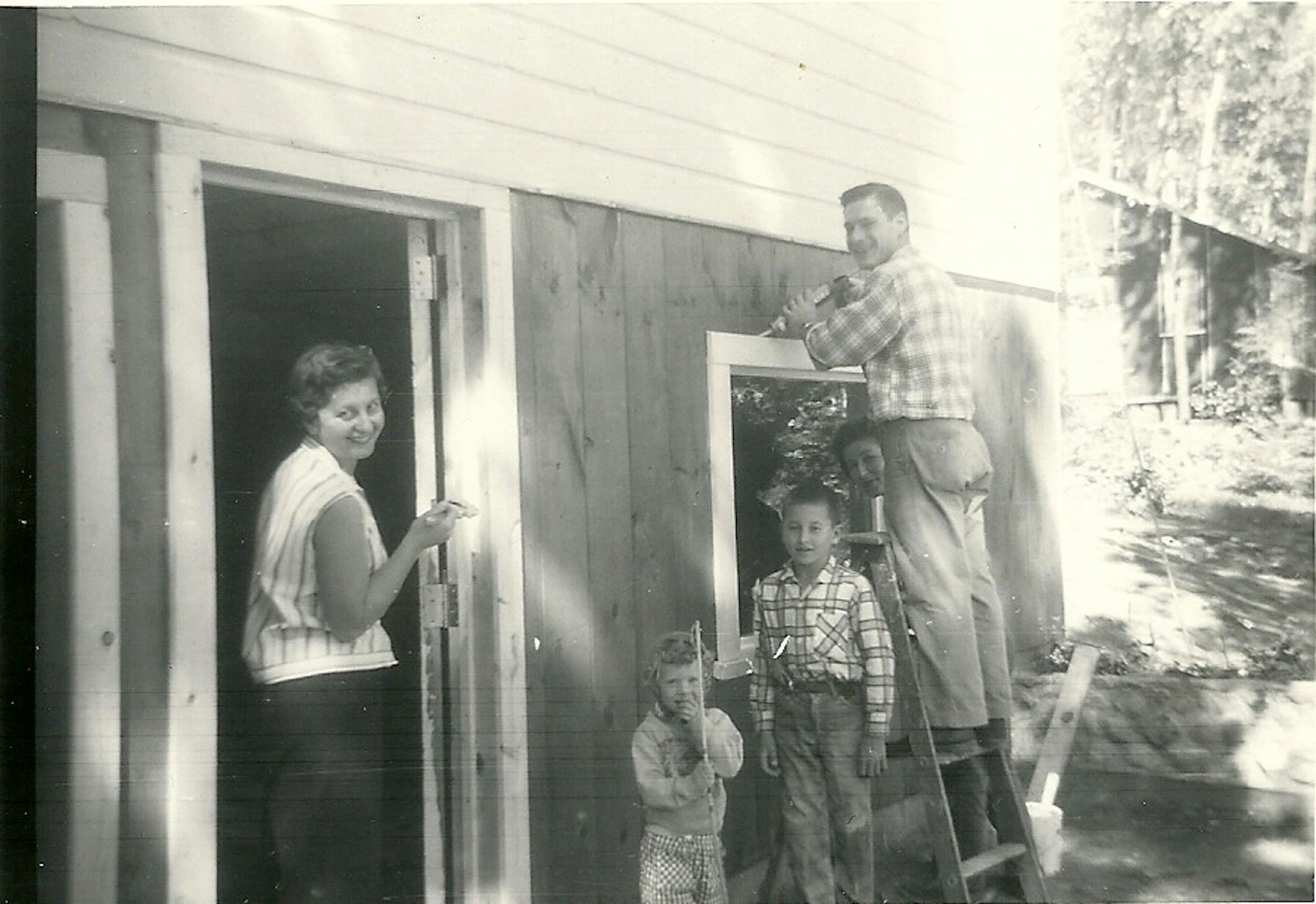 Friends and family helped build the Blau family cabin. The author is pictured as a child (plaid shirt, near center) with his mother, Ann, (far left) and some family friends.