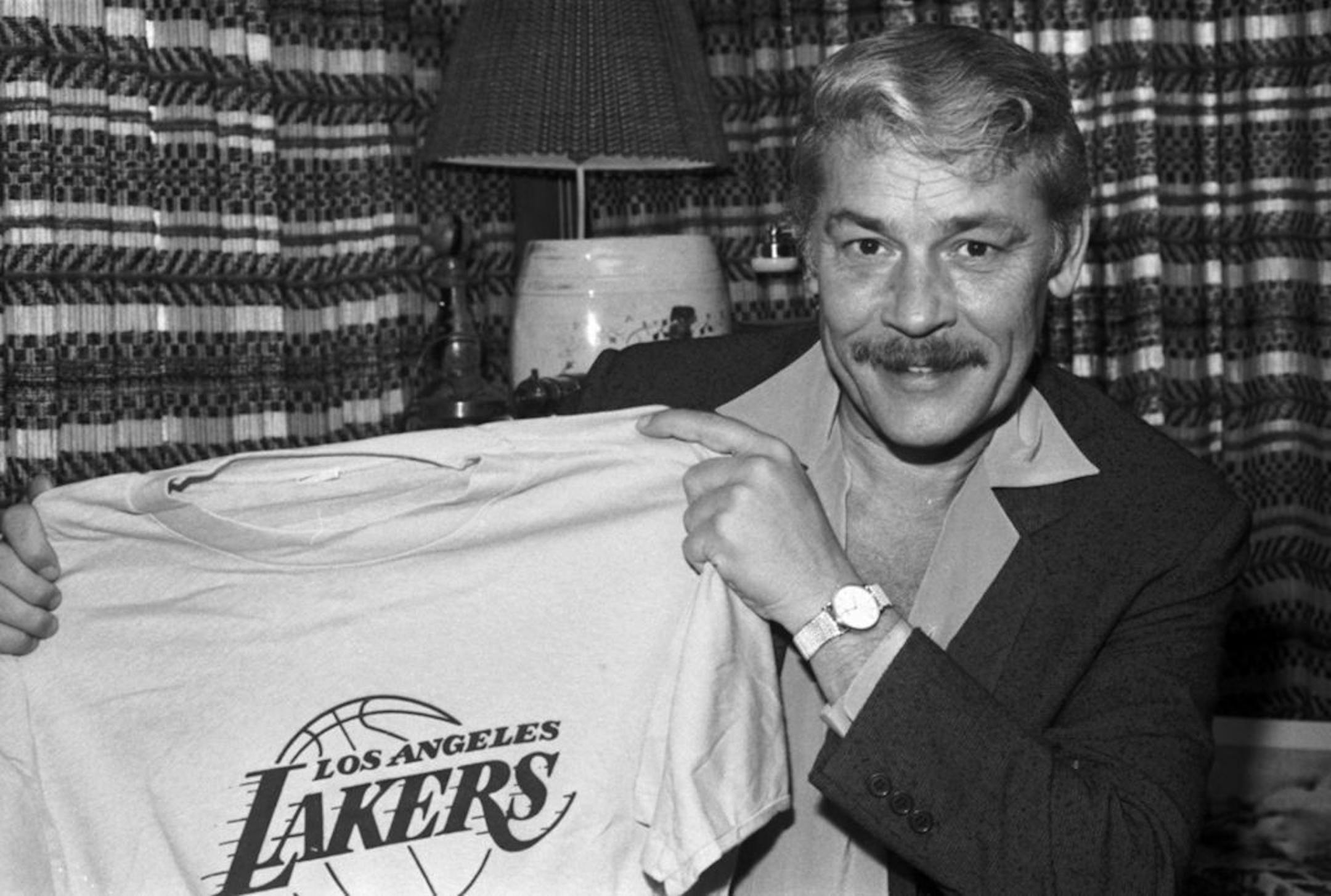 FILE - In this June 18, 1981 file photo, Jerry Buss holds a Los Angeles Lakers shirt in Los Angeles. Buss died Monday, Feb. 18, 2013. Buss, the Lakers' playboy owner who shepherded the NBA franchise to 10 championships, has died. He was 80. Bob Steiner, an assistant to Buss, confirmed Monday, Feb. 18, 2013 that Buss had died in Los Angeles. Further details were not available.
