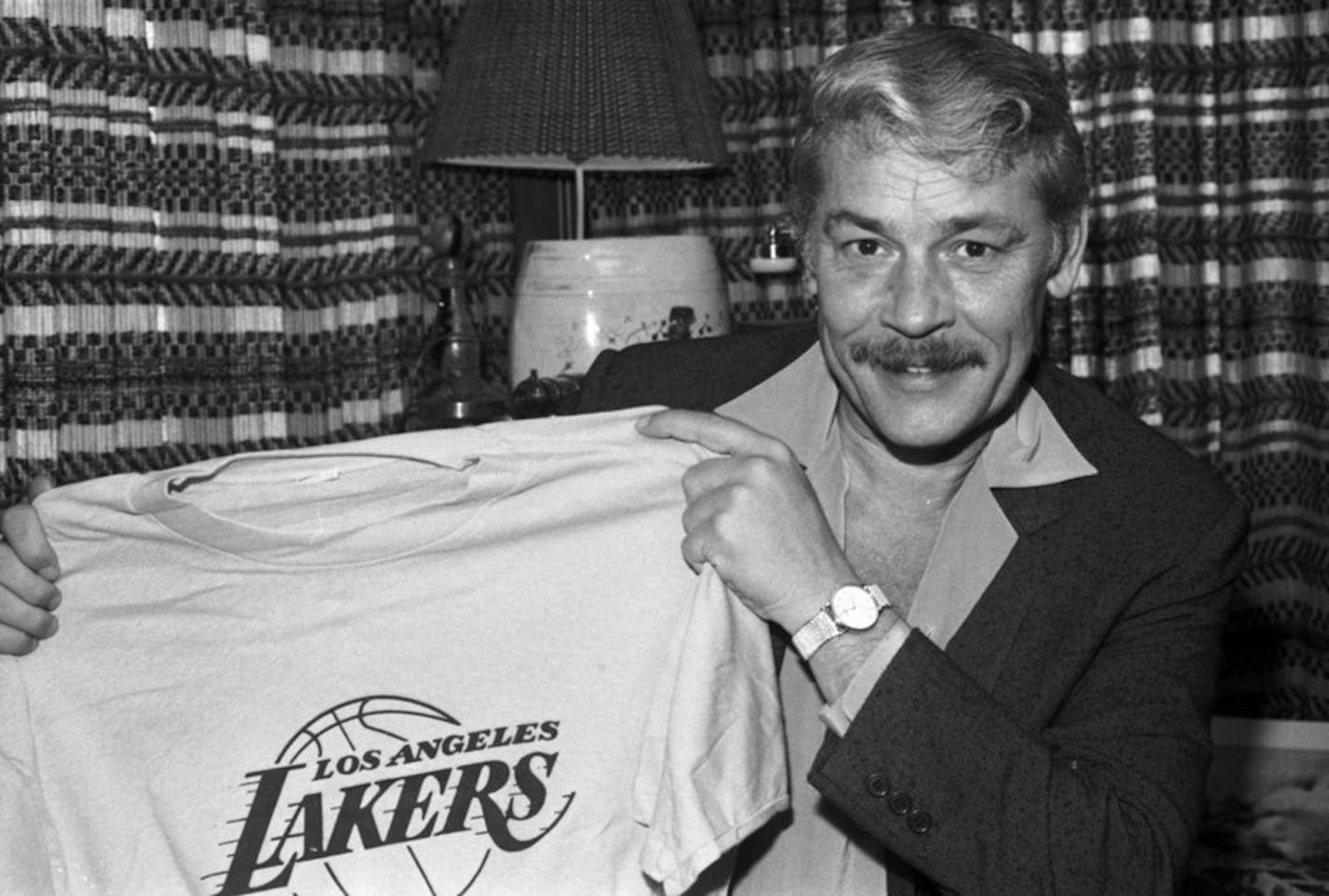 FILE - In this June 18, 1981 file photo, Jerry Buss holds a Los Angeles Lakers shirt in Los Angeles. Buss died Monday, Feb. 18, 2013. Buss, the Lakers' playboy owner who shepherded the NBA franchise to 10 championships, has died. He was 80. Bob Steiner, an assistant to Buss, confirmed Monday, Feb. 18, 2013 that Buss had died in Los Angeles. Further details were not available.