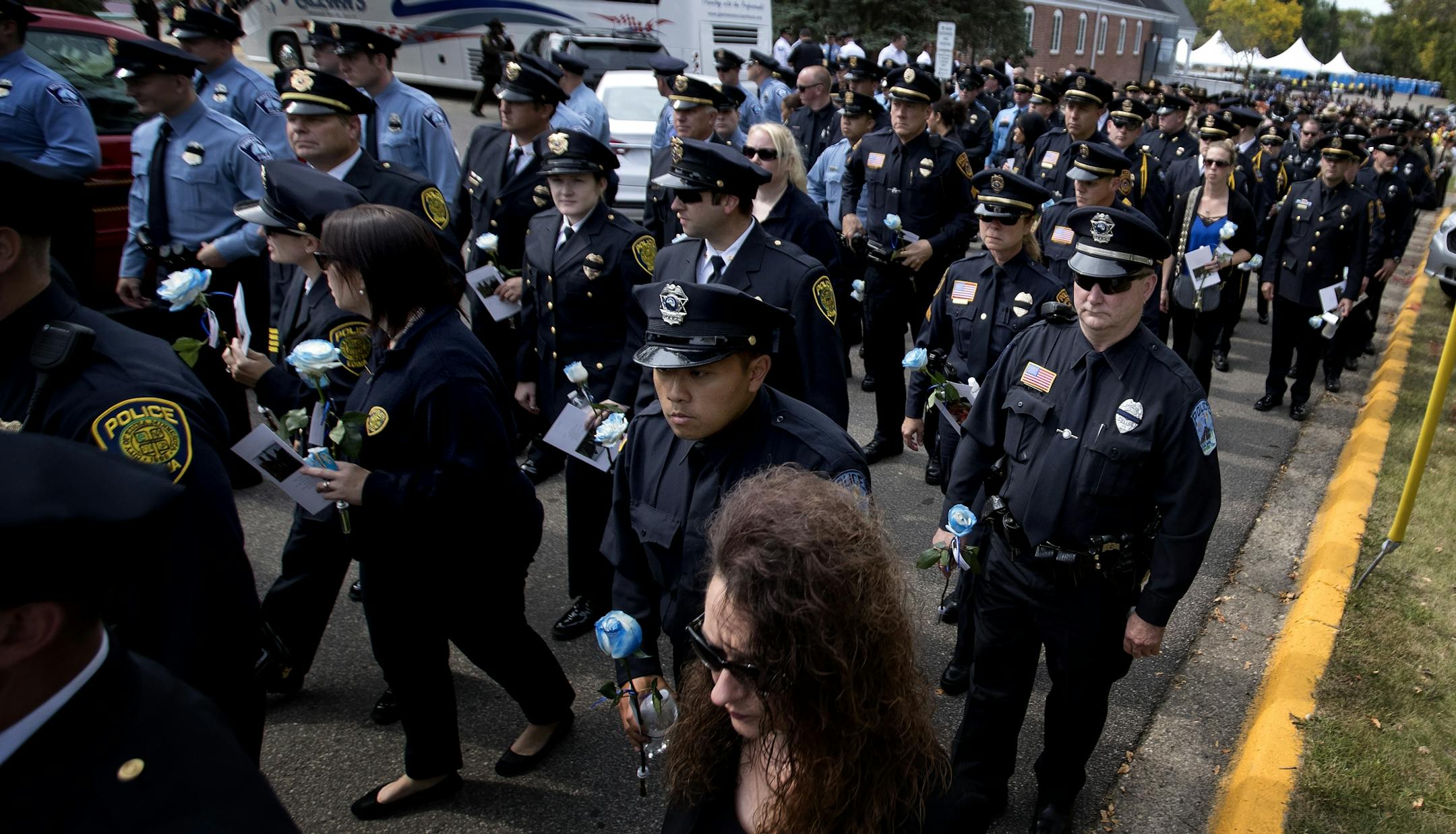 Law enforcement officers walked out of the overflow area at the end of the funeral service for officer William Mathews at the Wayzata Free Church.