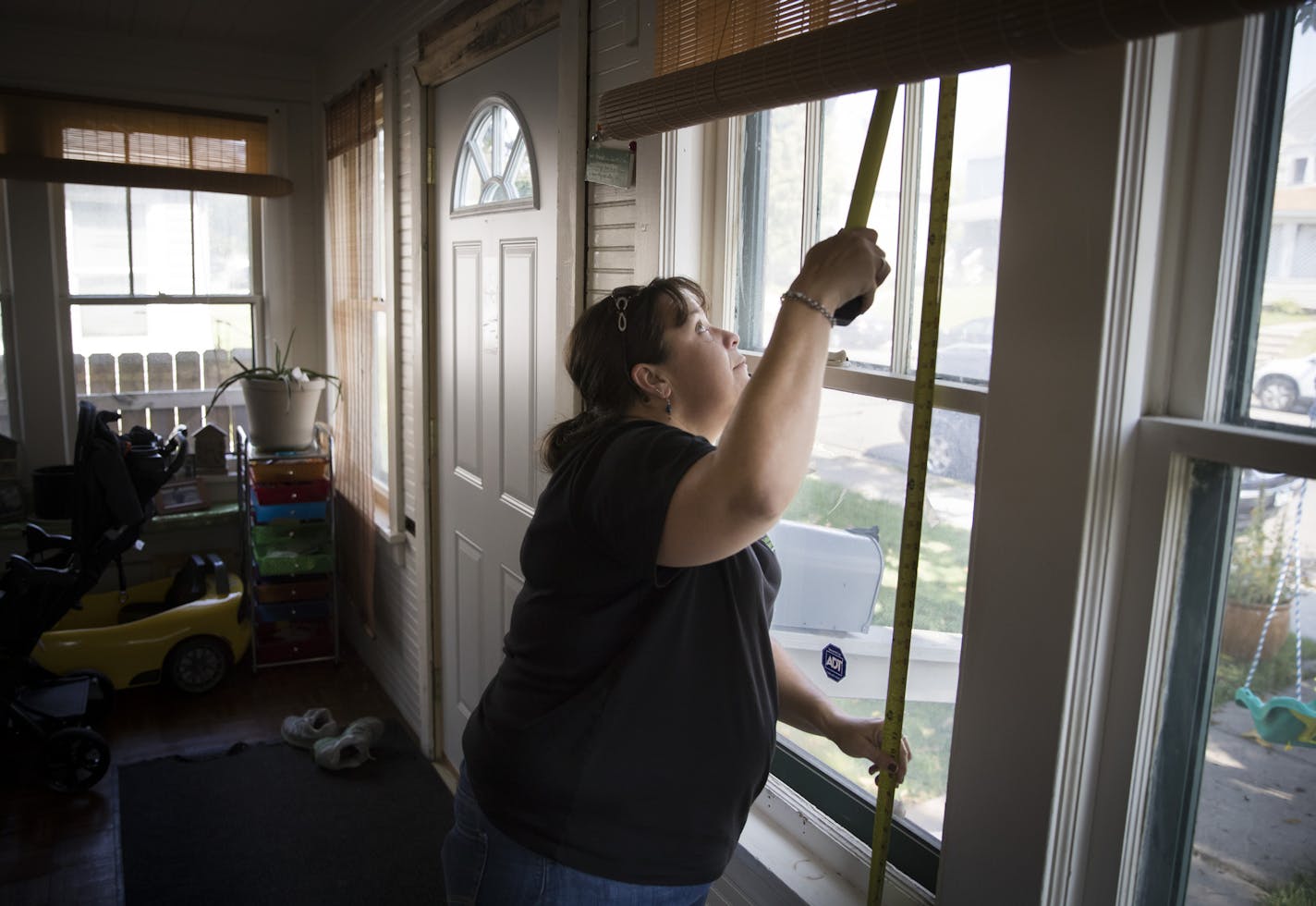 Tasha Julius, production manager for the nonprofit Sustainable Resource Center, measured windows for replacements at the home of Braulia Rendon.