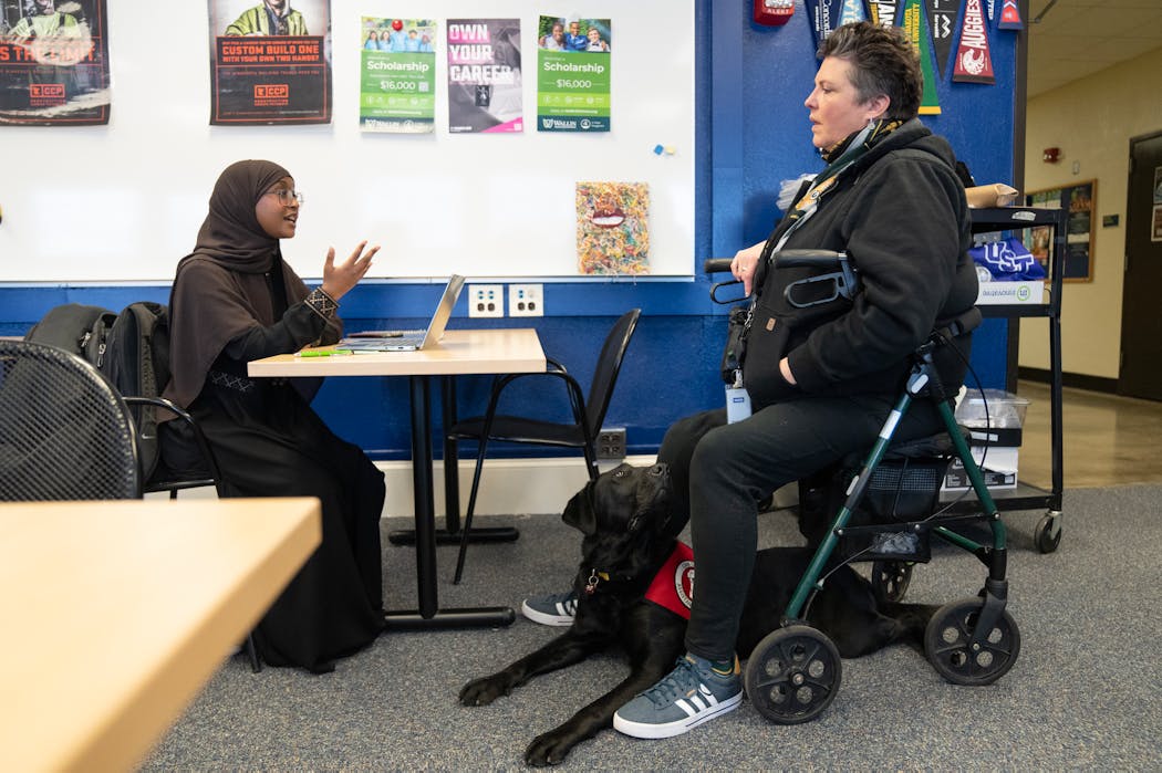 As Lambeau looked on, Nora Guerin (right) talked with student Sahra Hamed, who plans to become a lawyer, in the Career and College Readiness Center at Edison High School in Minneapolis.